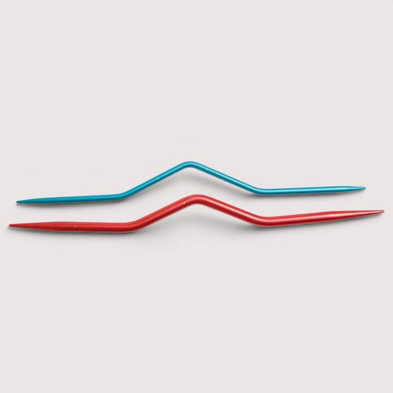 Two colourful knitting cable needles, one red and one blue, on a light gray background.