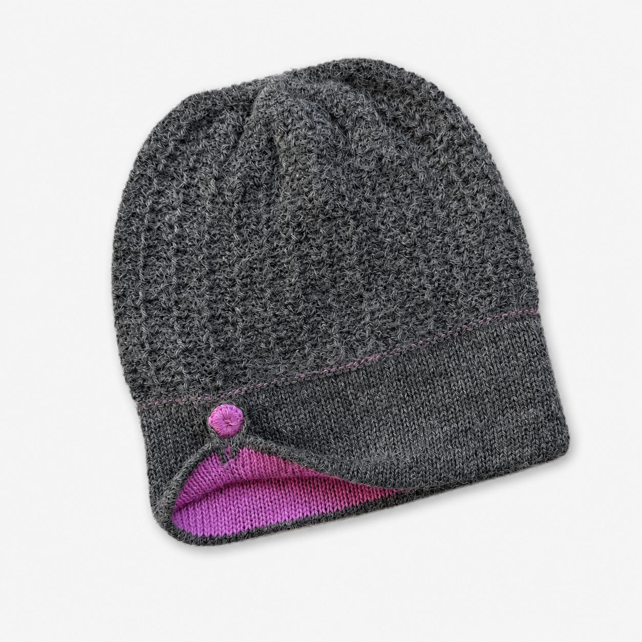 Gray knit alpaca beanie with pink interior on a white background