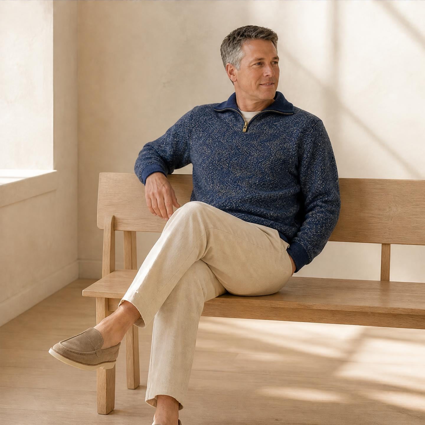 model on chair wearing Men’s alpaca half zip jumper with mock neck collar