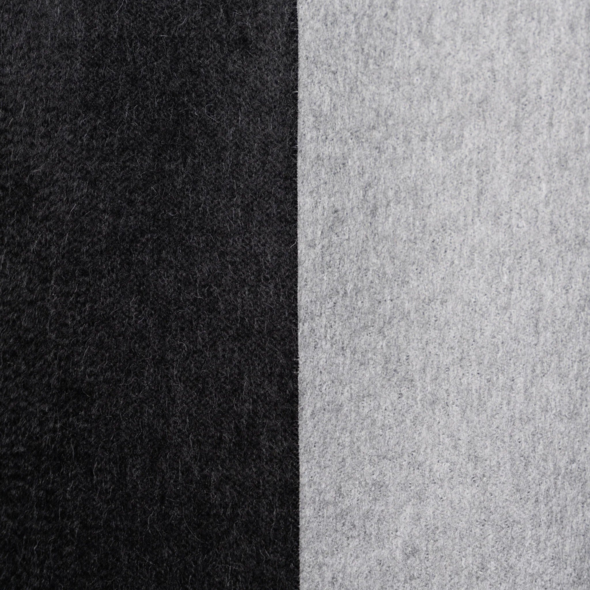 Close up of Black and grey Suri alpaca scarf styled on a man with contrasting reversible sides