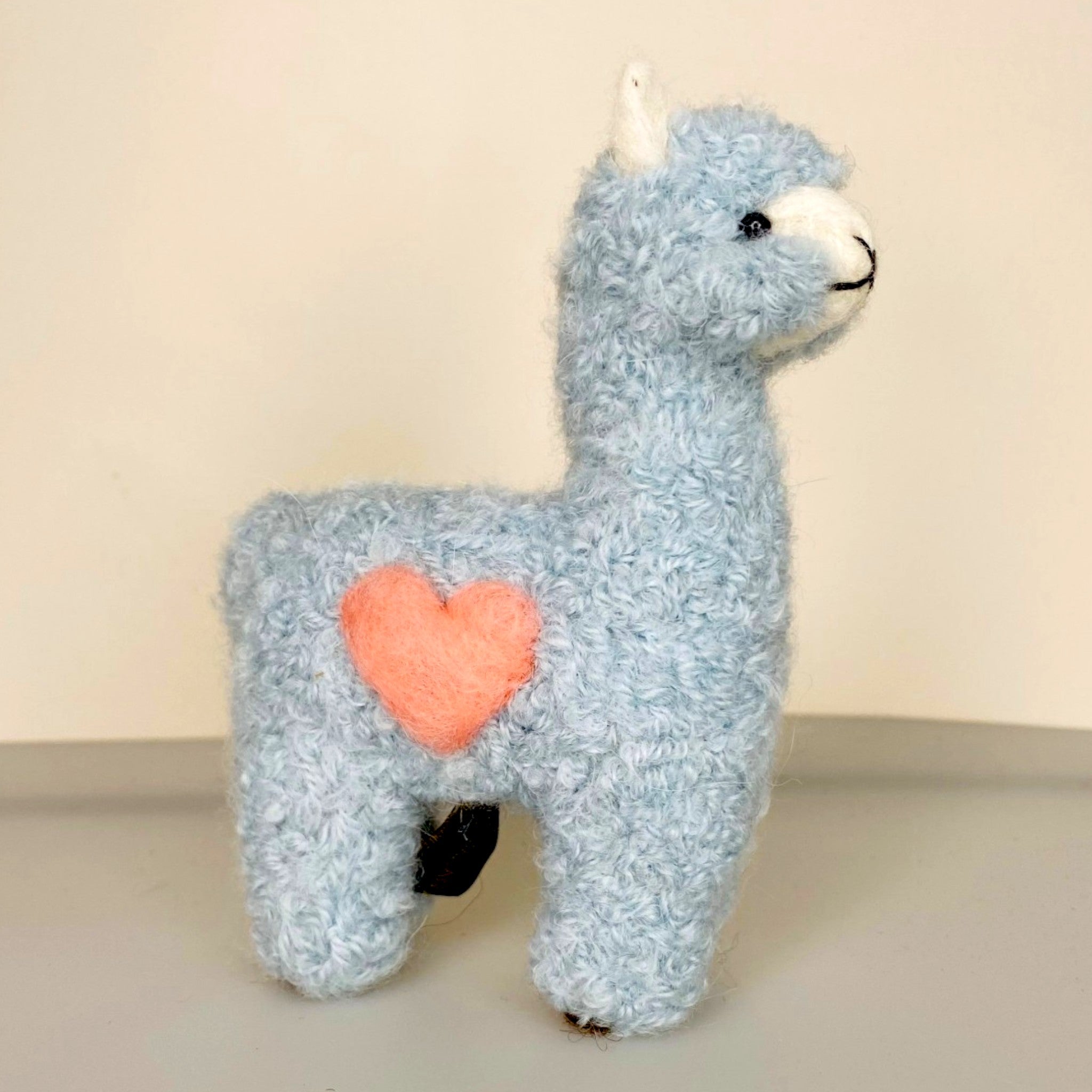 Needle felted alpaca Blue with pink heart, showing soft fibre and cute face.