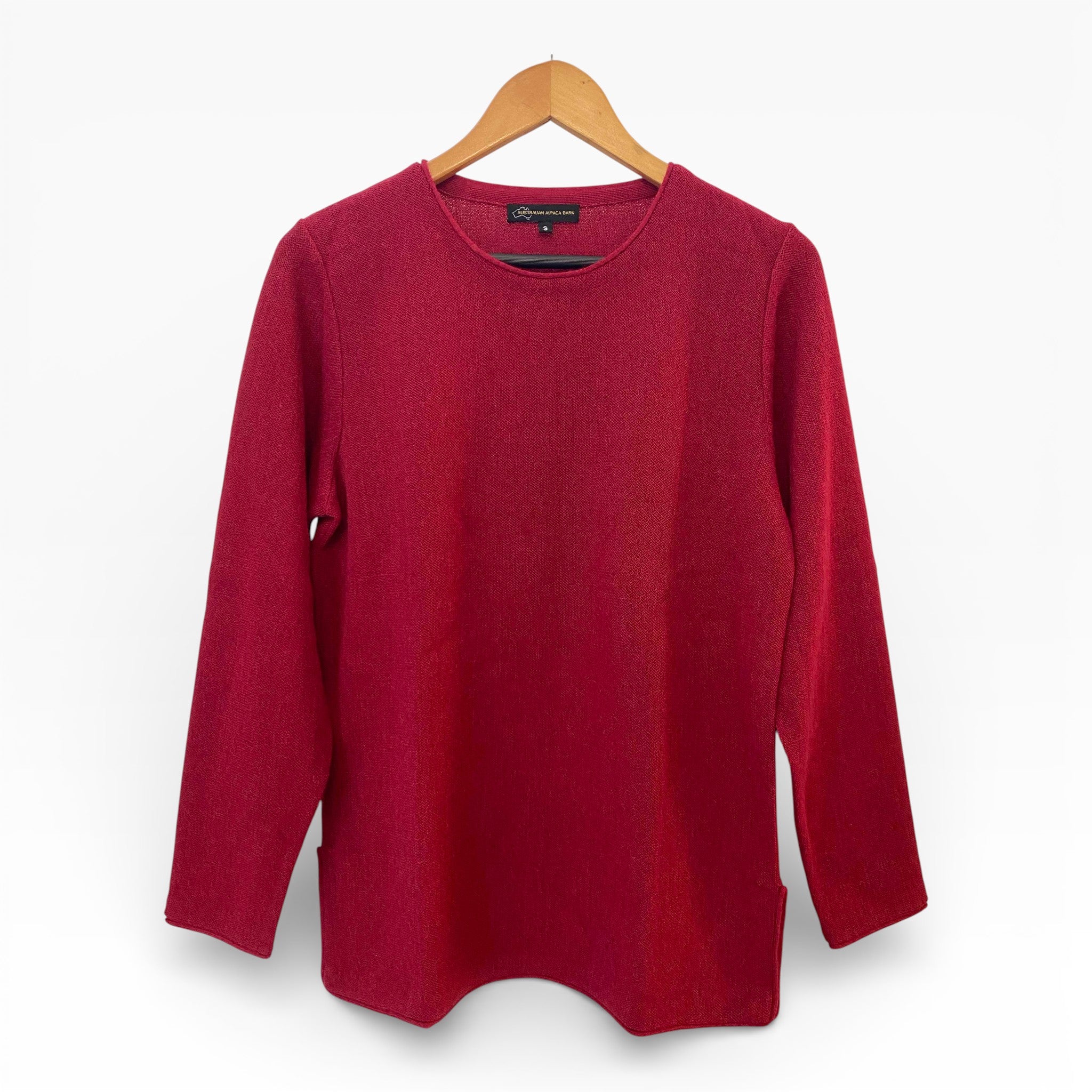 Red sweater on a wooden hanger against a white background