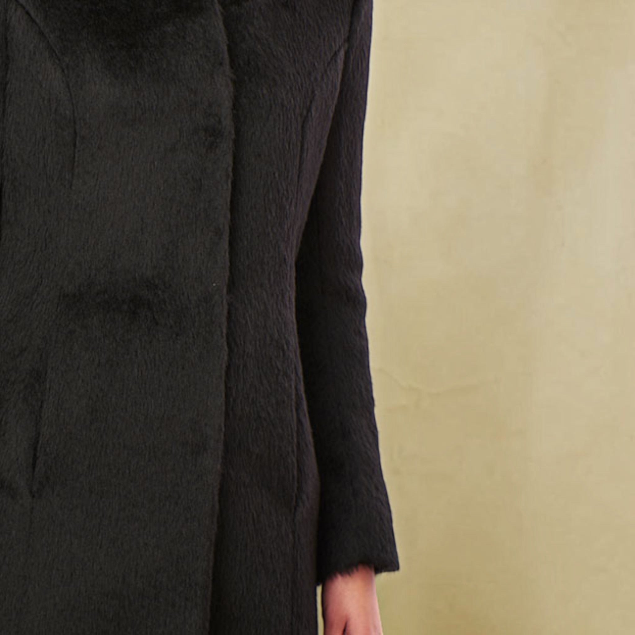 Close-up of the Theory coat showing soft black Suri alpaca texture