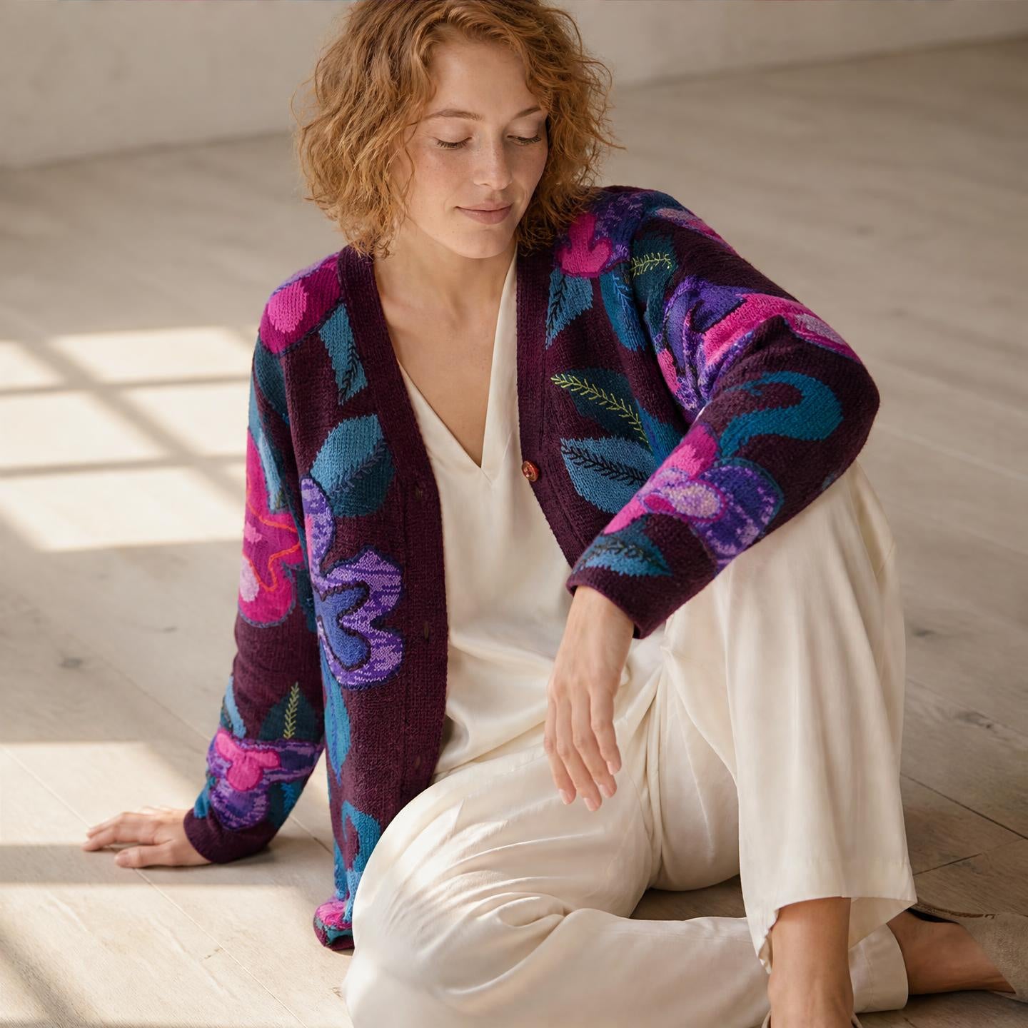 Model wearing Genevieve long hand knitted alpaca cardigan with plum floral design