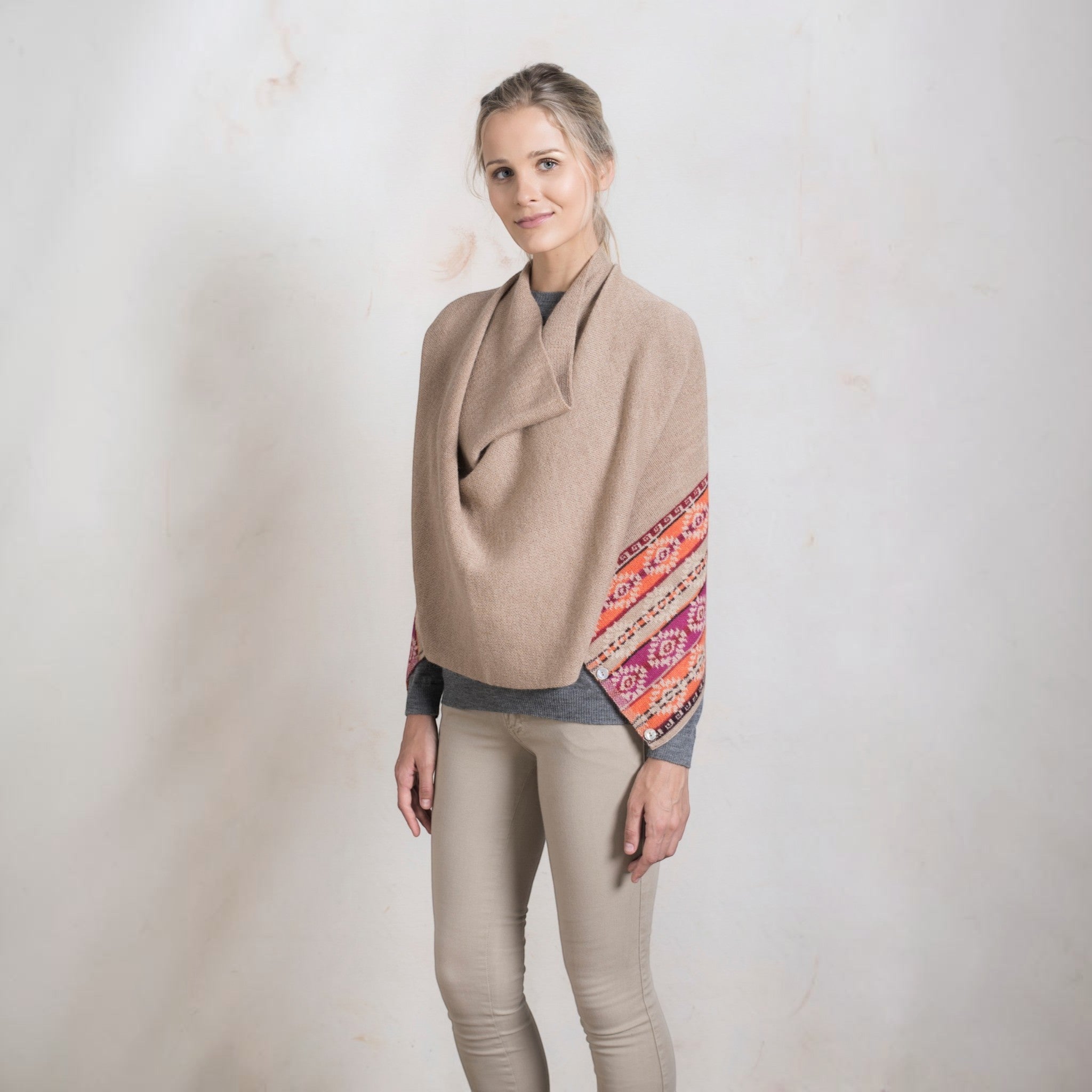 Model wearing versatile alpaca shawl closed with buttons at the ends.
