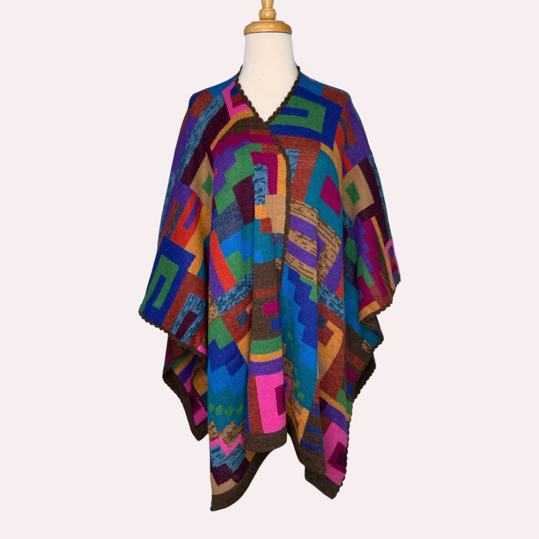 Luxury alpaca cape in colourful geometric design, elegant cold weather accessory.