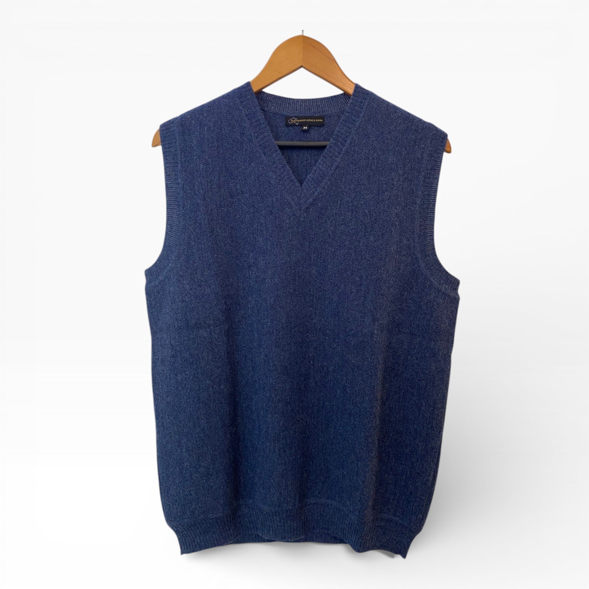 Blue sweater vest on a hanger against a white background
