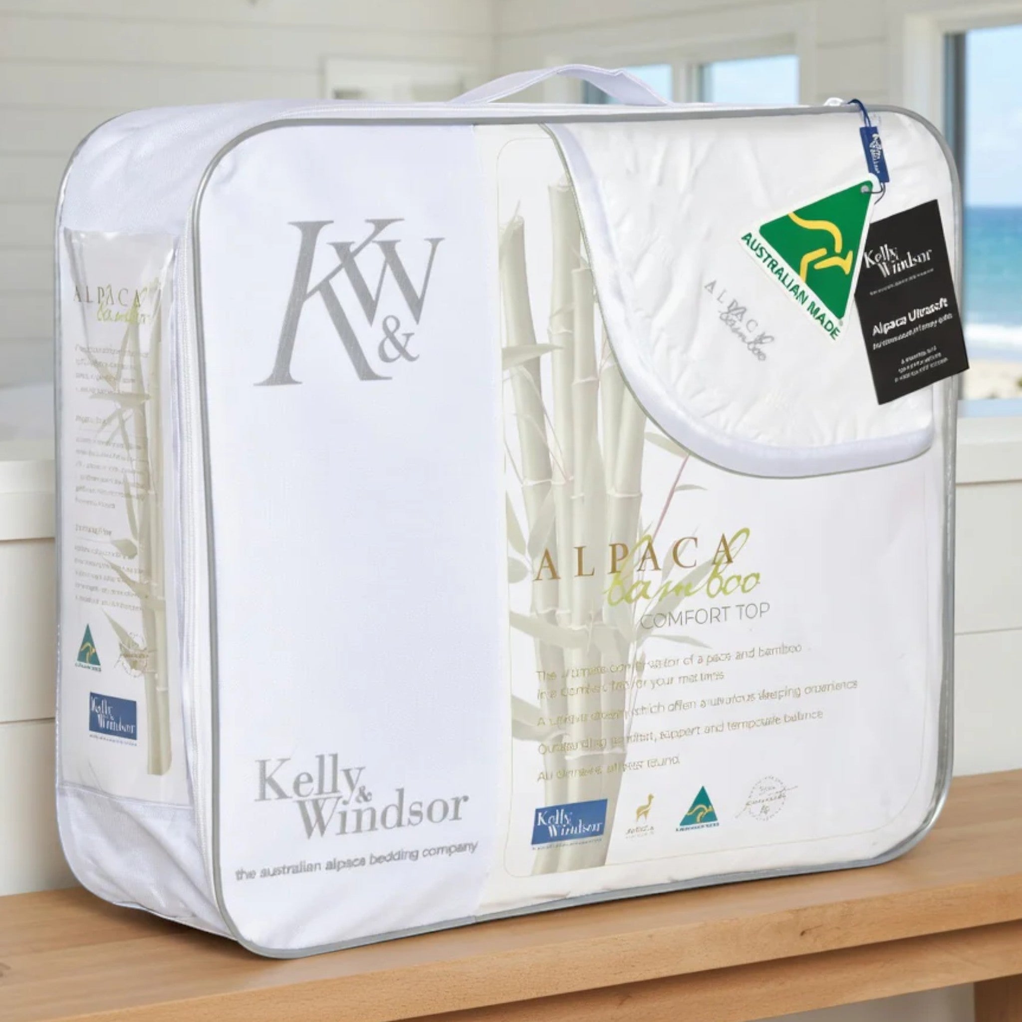 Kelly Windsor alpaca blanket on a wooden surface with branding visible