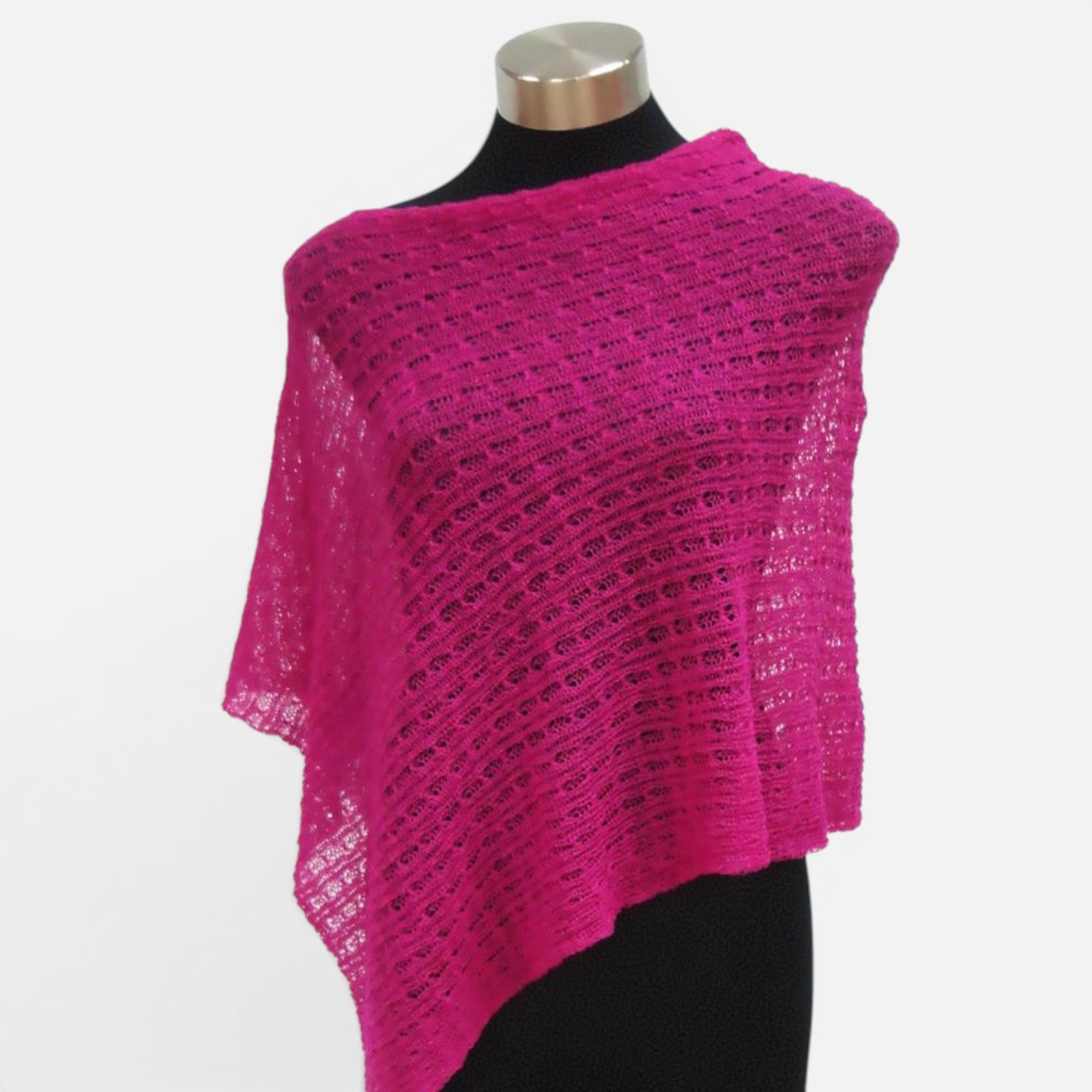 Fuchsia pink lacy alpaca poncho with lightweight lace knit displayed on a mannequin