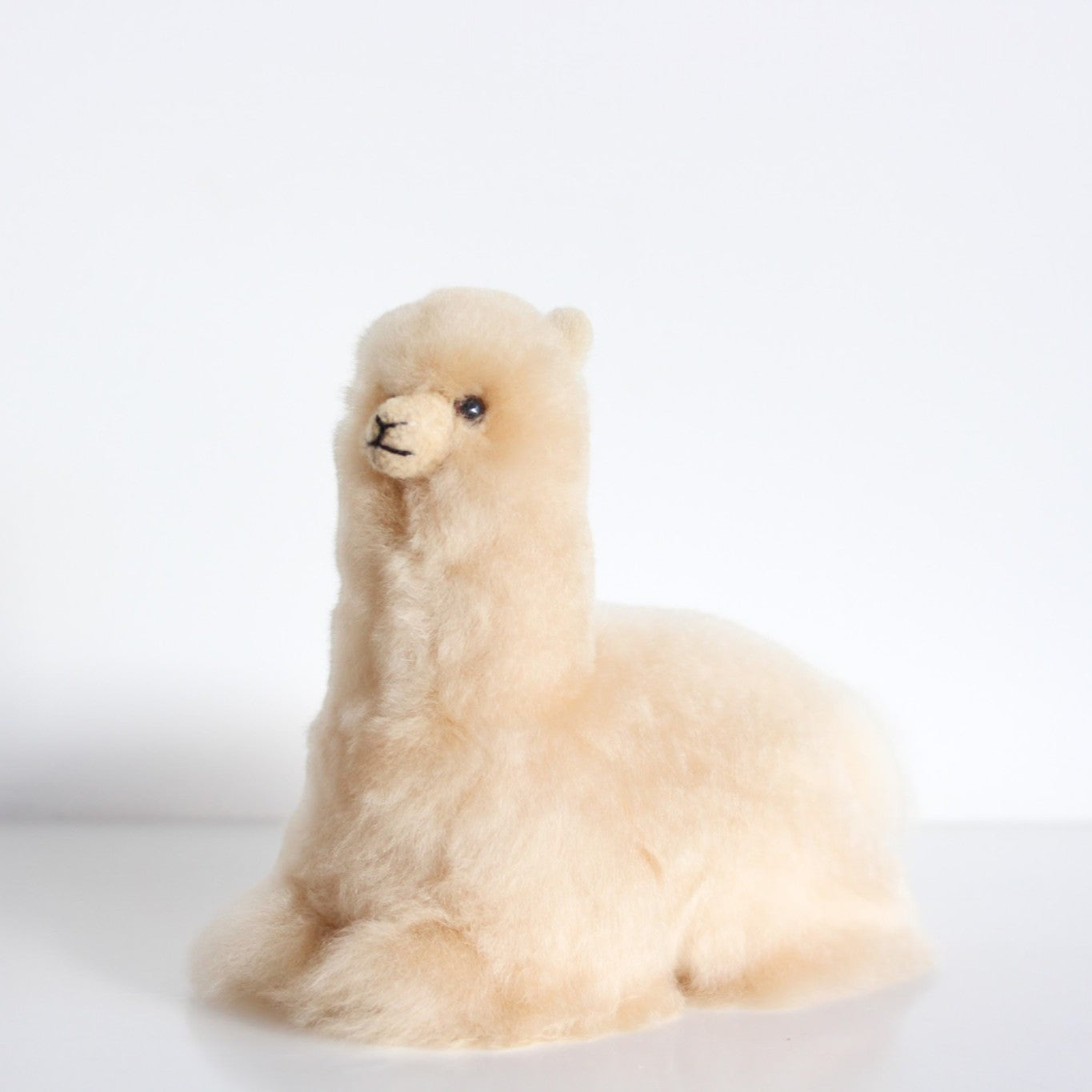 Cream alpaca ornament in a relaxed lying pose, measuring approximately 20 × 18cm
