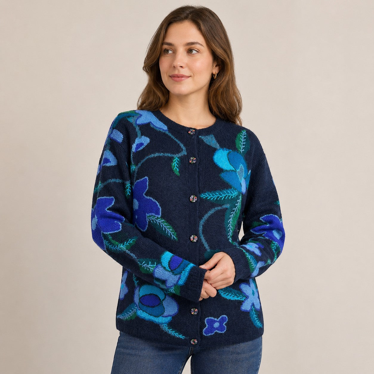 Woman wearing colourful navy alpaca cardigan with floral patterns and unique hand painted buttons.
