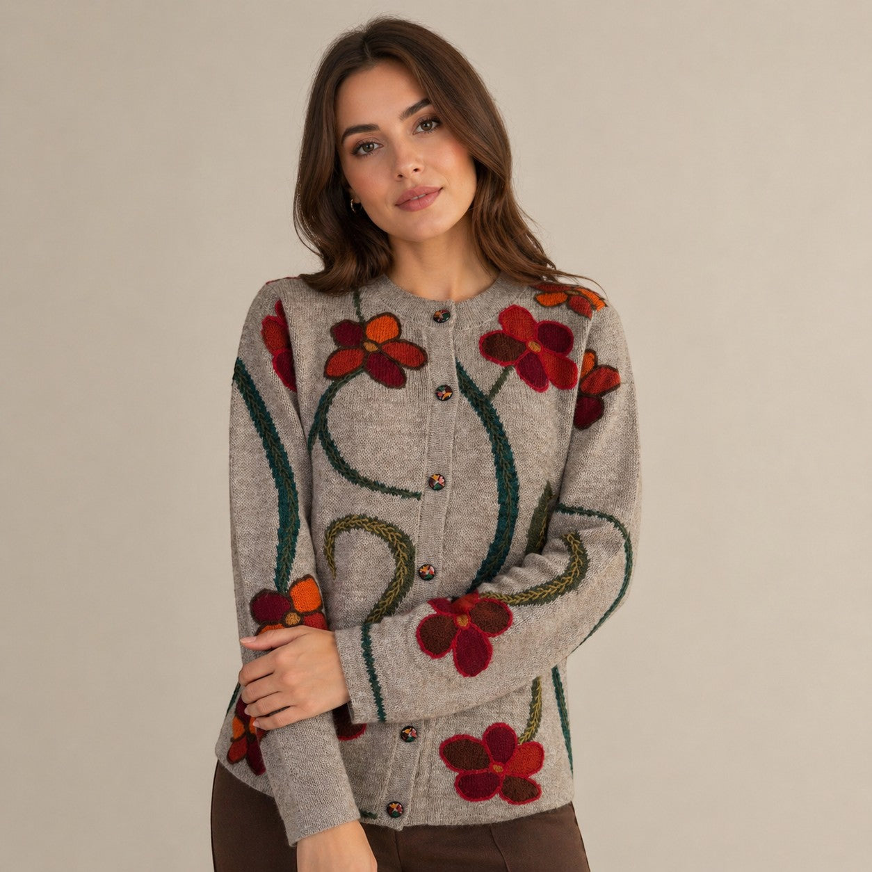 Lady wearing beige alpaca knit cardigan with floral pattern with artisan buttons.