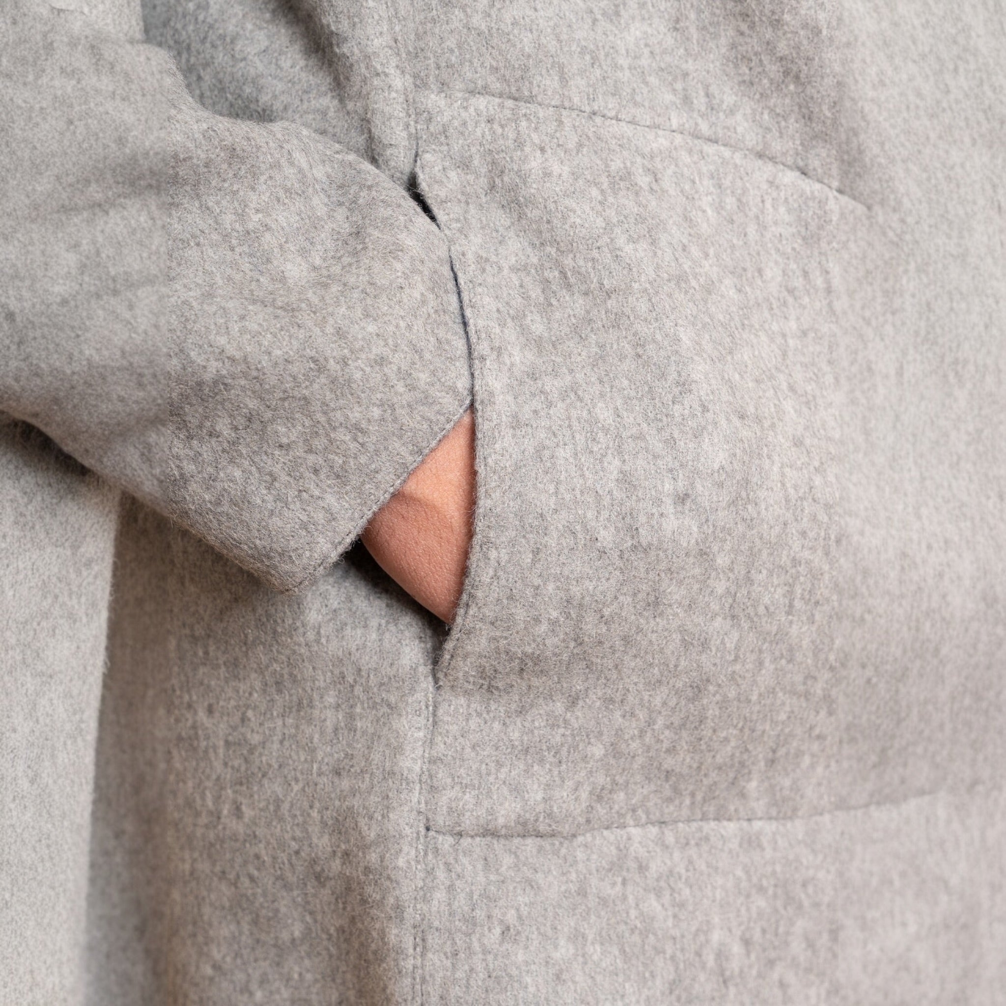 Close-up Pocket detail on men’s reversible alpaca jacket with hood.