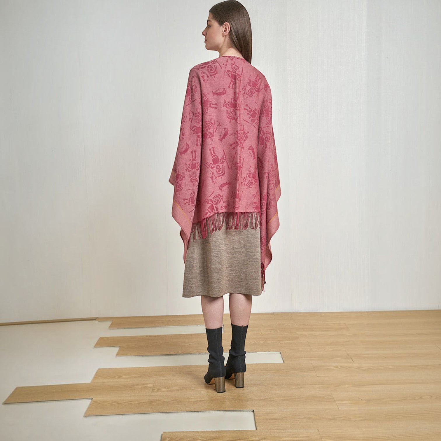 Back view of the women’s fuchsia alpaca cape with asymmetric hem and fringe detail