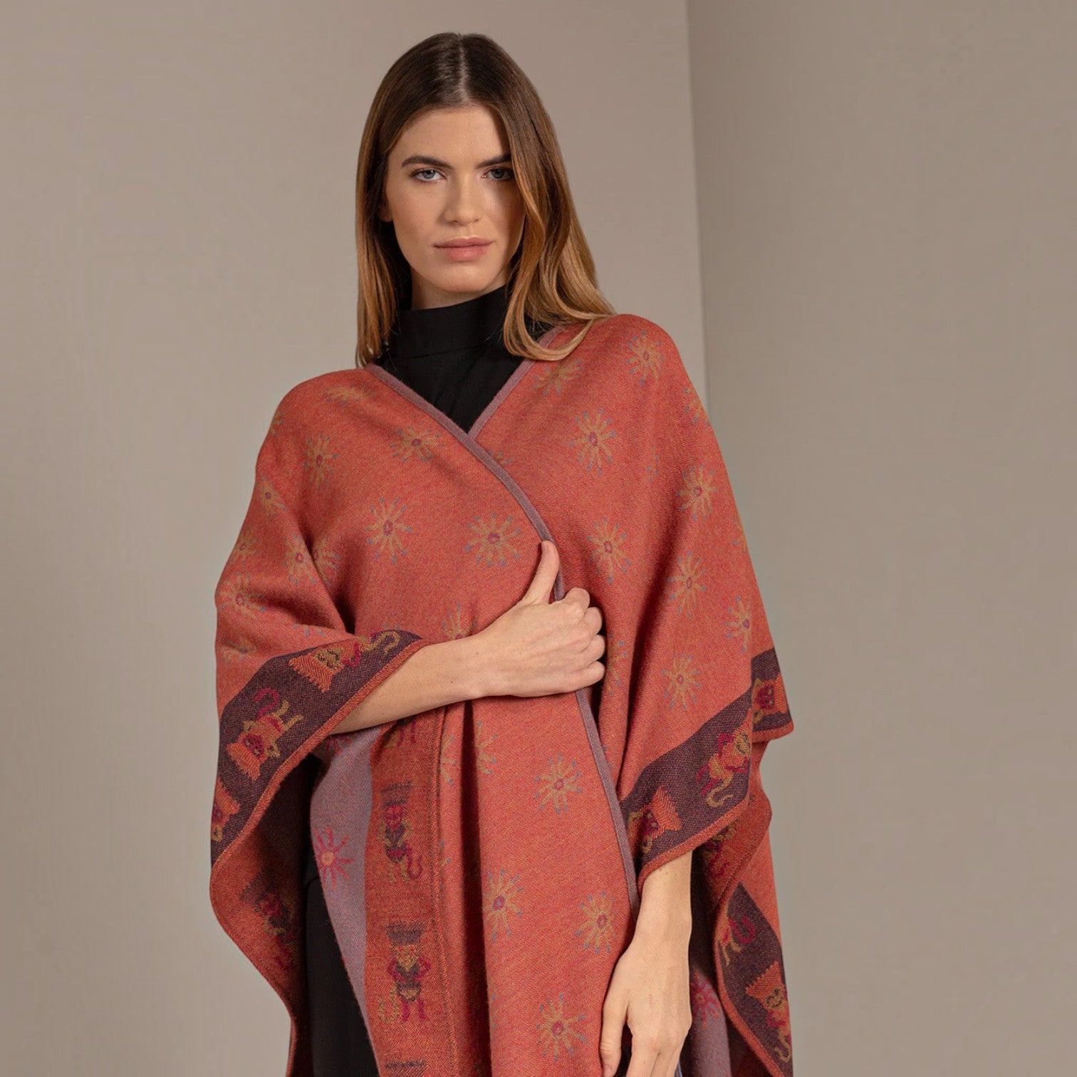 Front view of the Nazca 43 mauve alpaca cape with patterned border and flowing asymmetric drape
