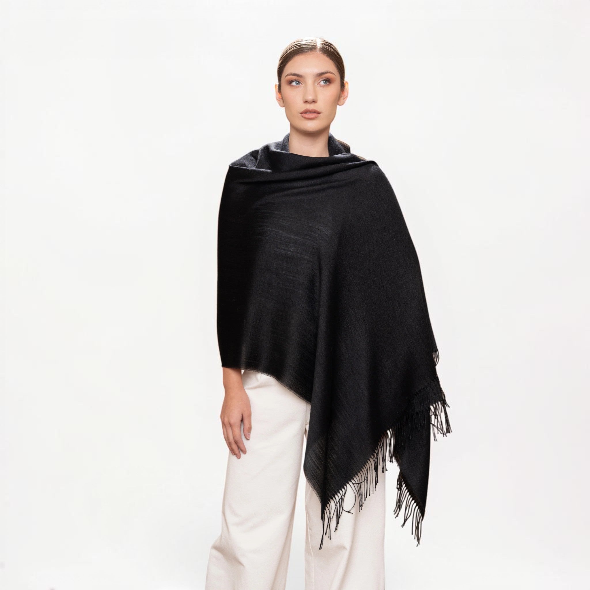 Model draped in black baby alpaca silk shawl, elegant lightweight winter wrap.