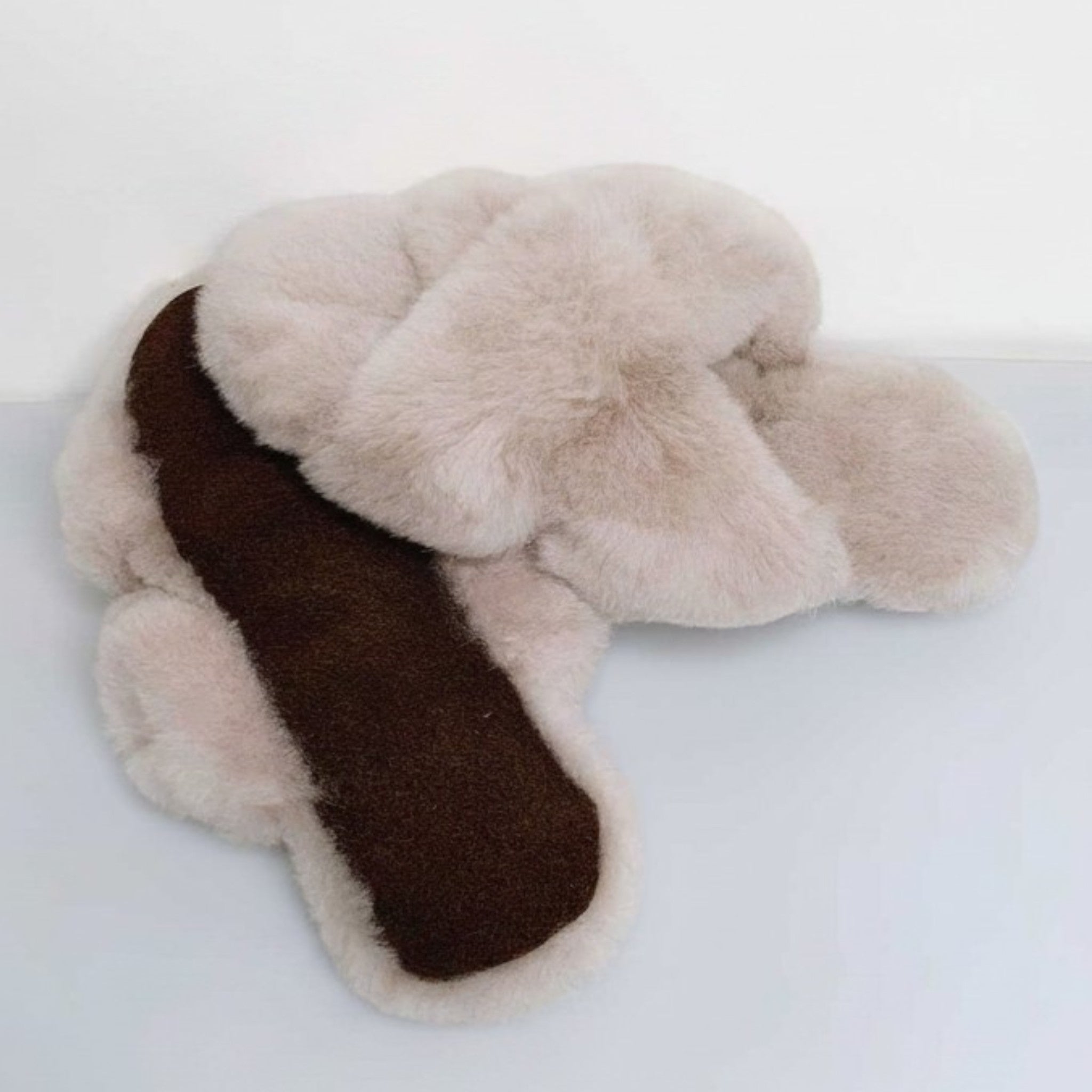 Handcrafted sand alpaca fur slippers featuring a soft crossed design and leather sole