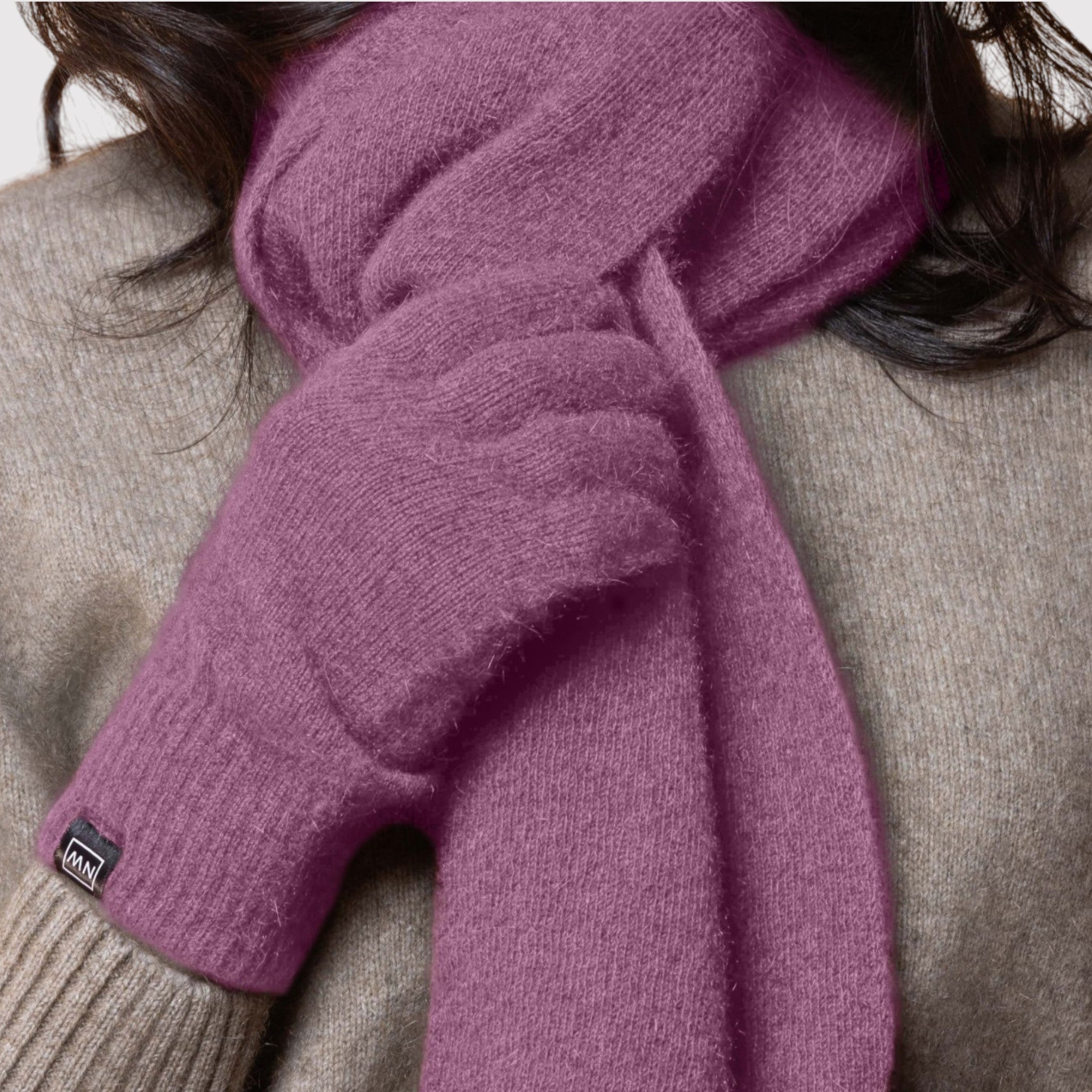 Person wearing a purple possum scarf and gloves with a beige sweater.