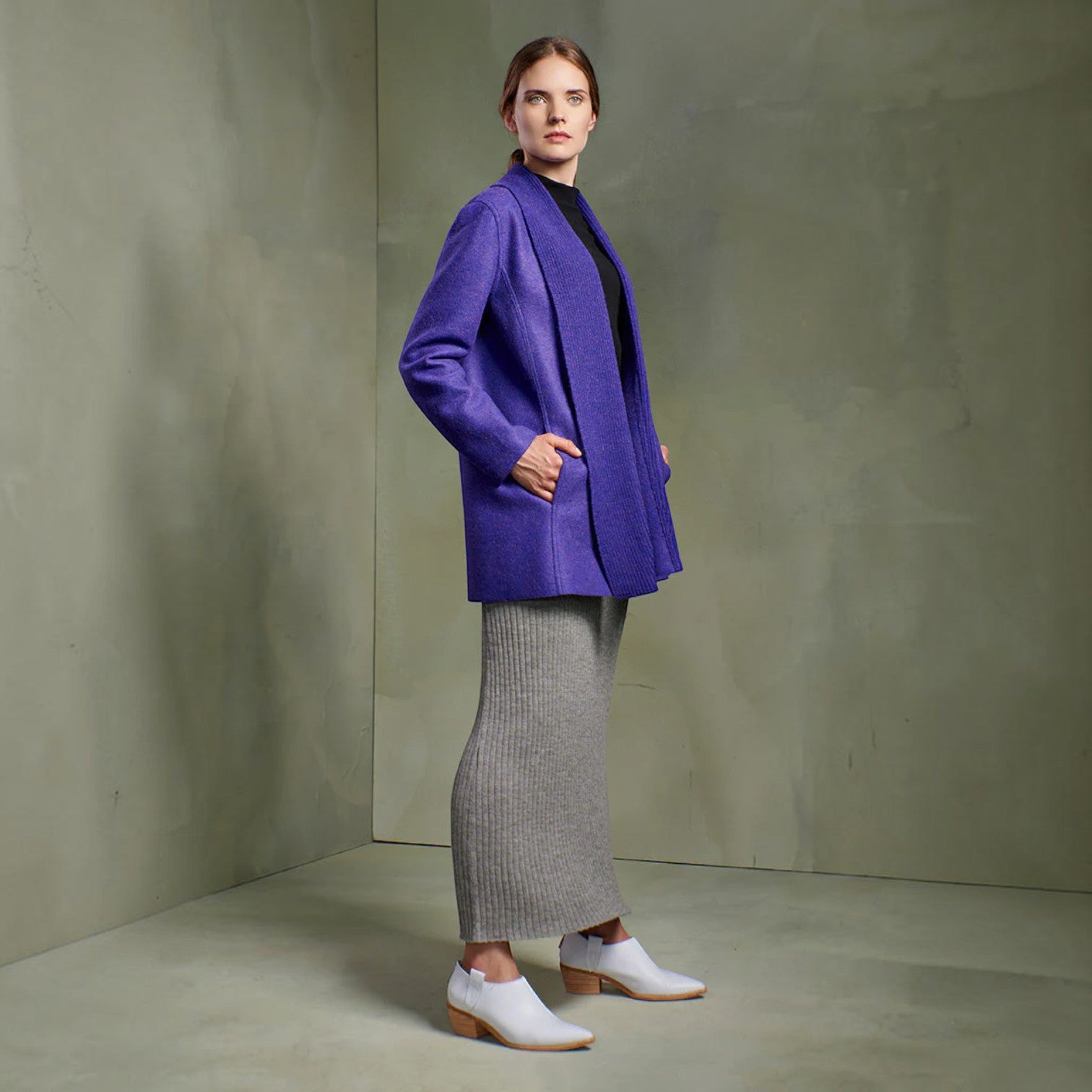 Full-length view of women’s purple alpaca blend coat styled with a grey knit skirt