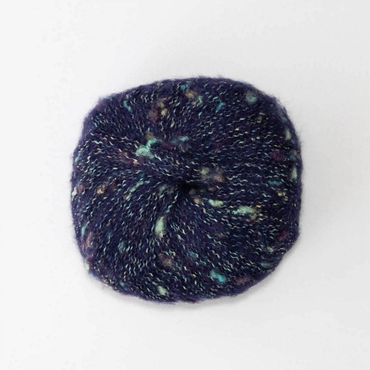 Overhead view of Navy Indulge baby alpaca bouclé yarn without a label.