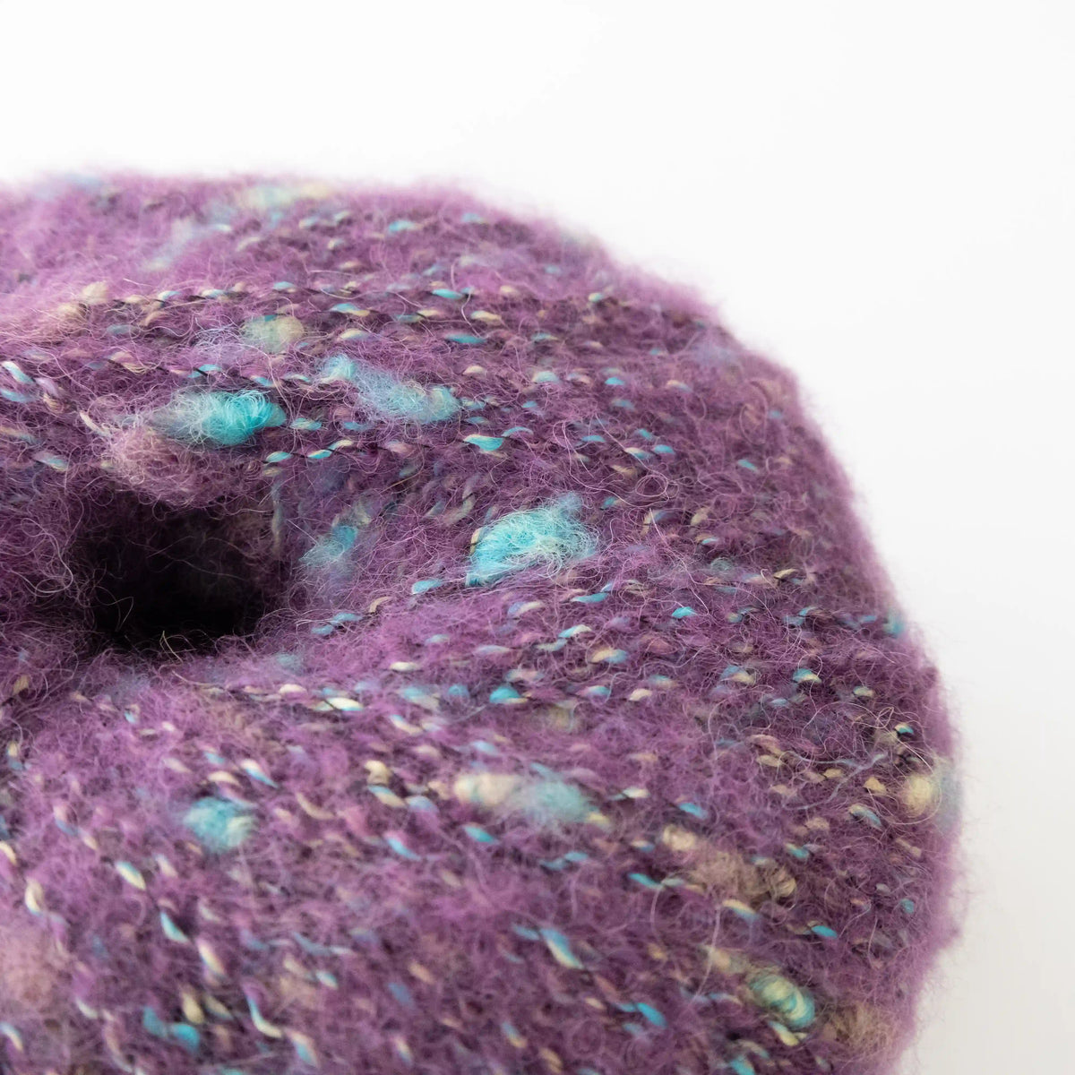 Close-up of Amethyst Indulge baby alpaca bouclé yarn showing its looped texture.