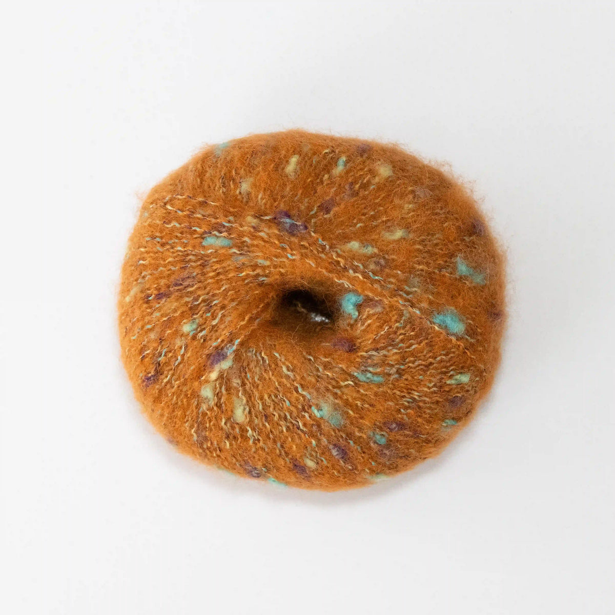 Overhead view of Orange Indulge baby alpaca bouclé yarn without a label