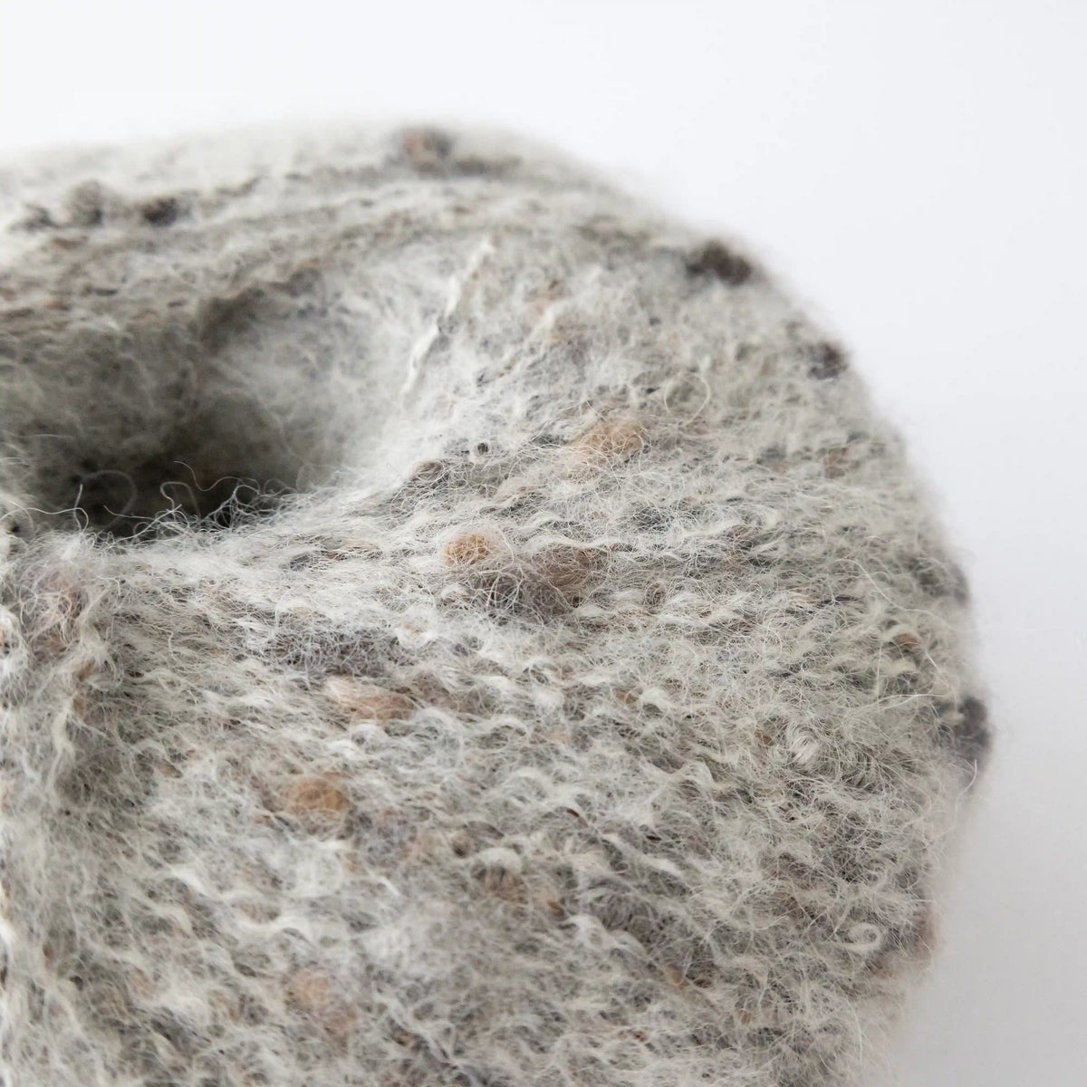 Close-up of Silverwhite Indulge baby alpaca bouclé yarn showing its looped texture.