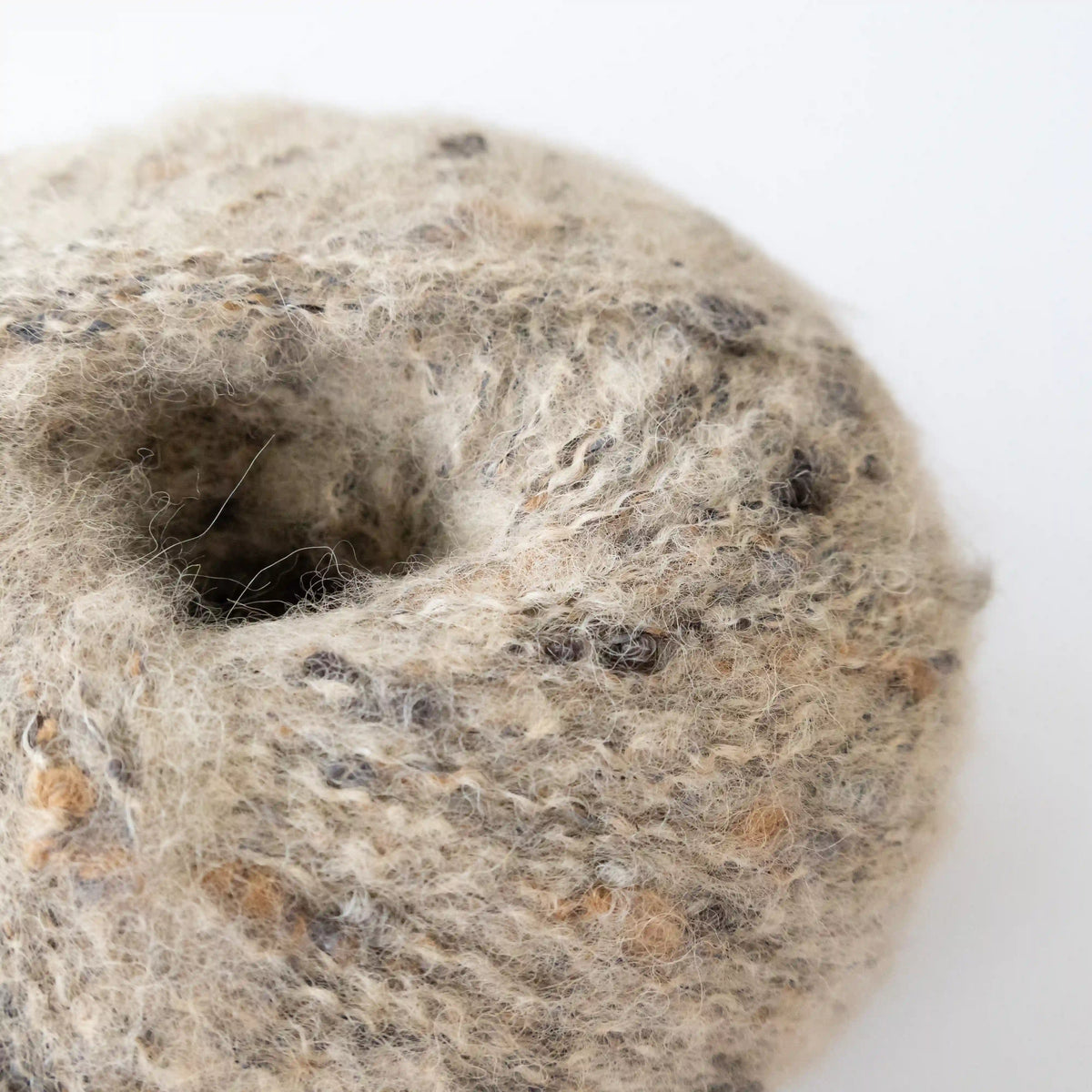 Close-up of Nougat Indulge baby alpaca bouclé yarn showing its looped texture.