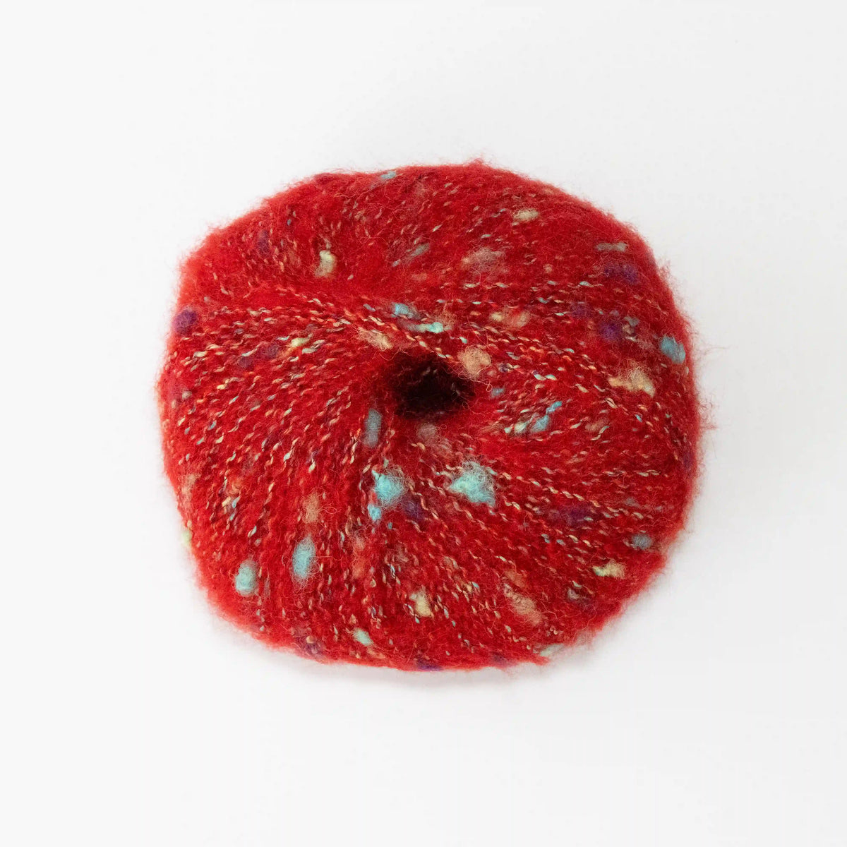Overhead view of Red Indulge baby alpaca bouclé yarn without a label.