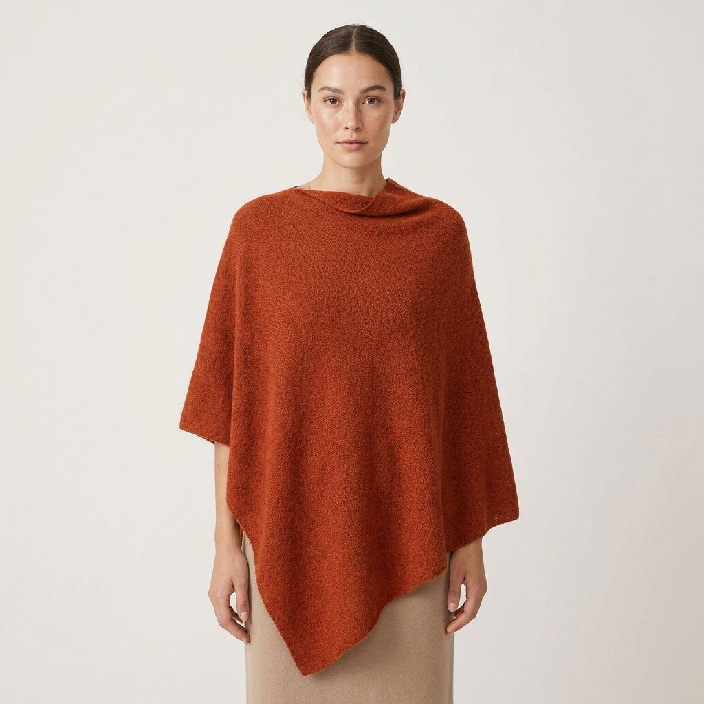 Sorpresa alpaca poncho in Rust, a warm earthy orange shade, shown on a female model