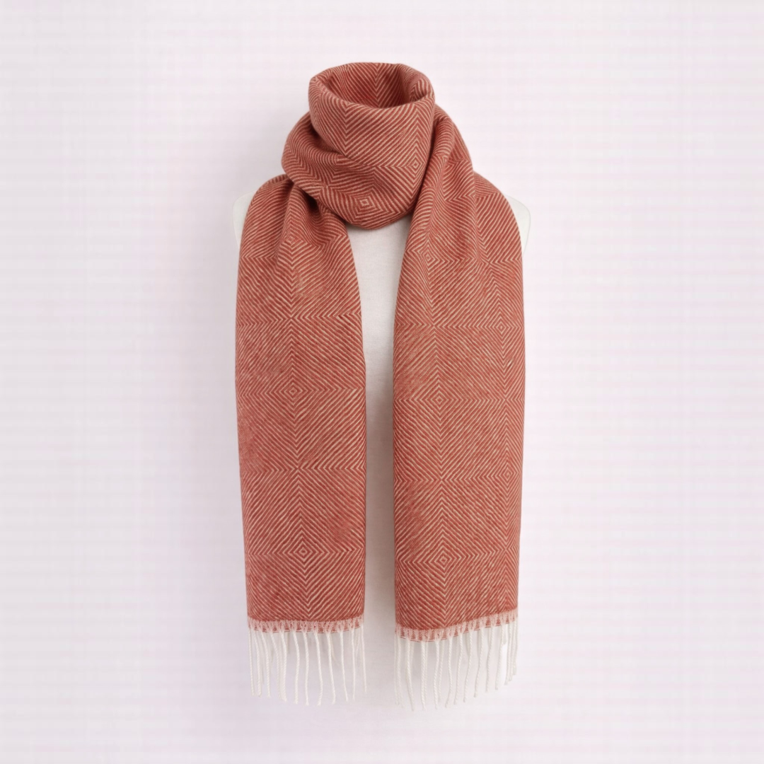 Baby alpaca scarf with pumpkin orange diamond design, elegant soft winter layer.