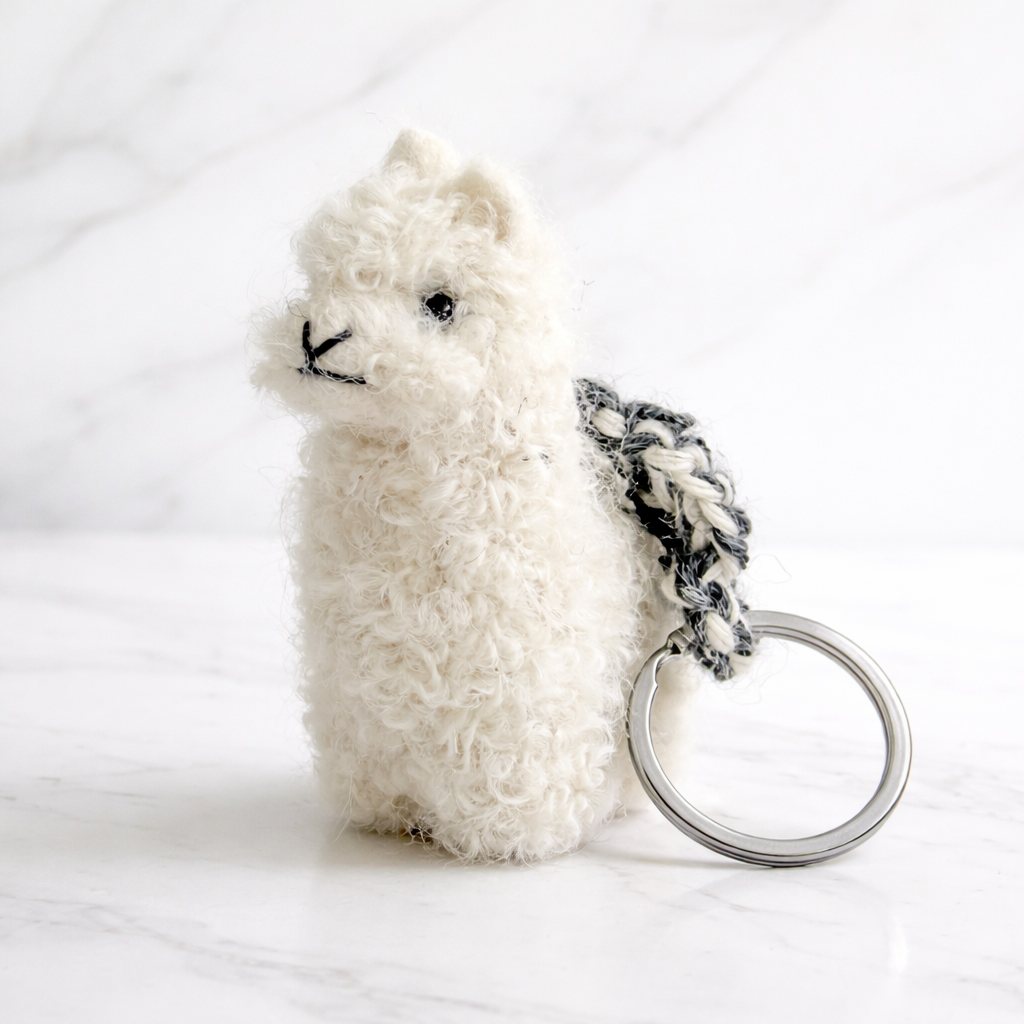 White needle felted alpaca on a keychain