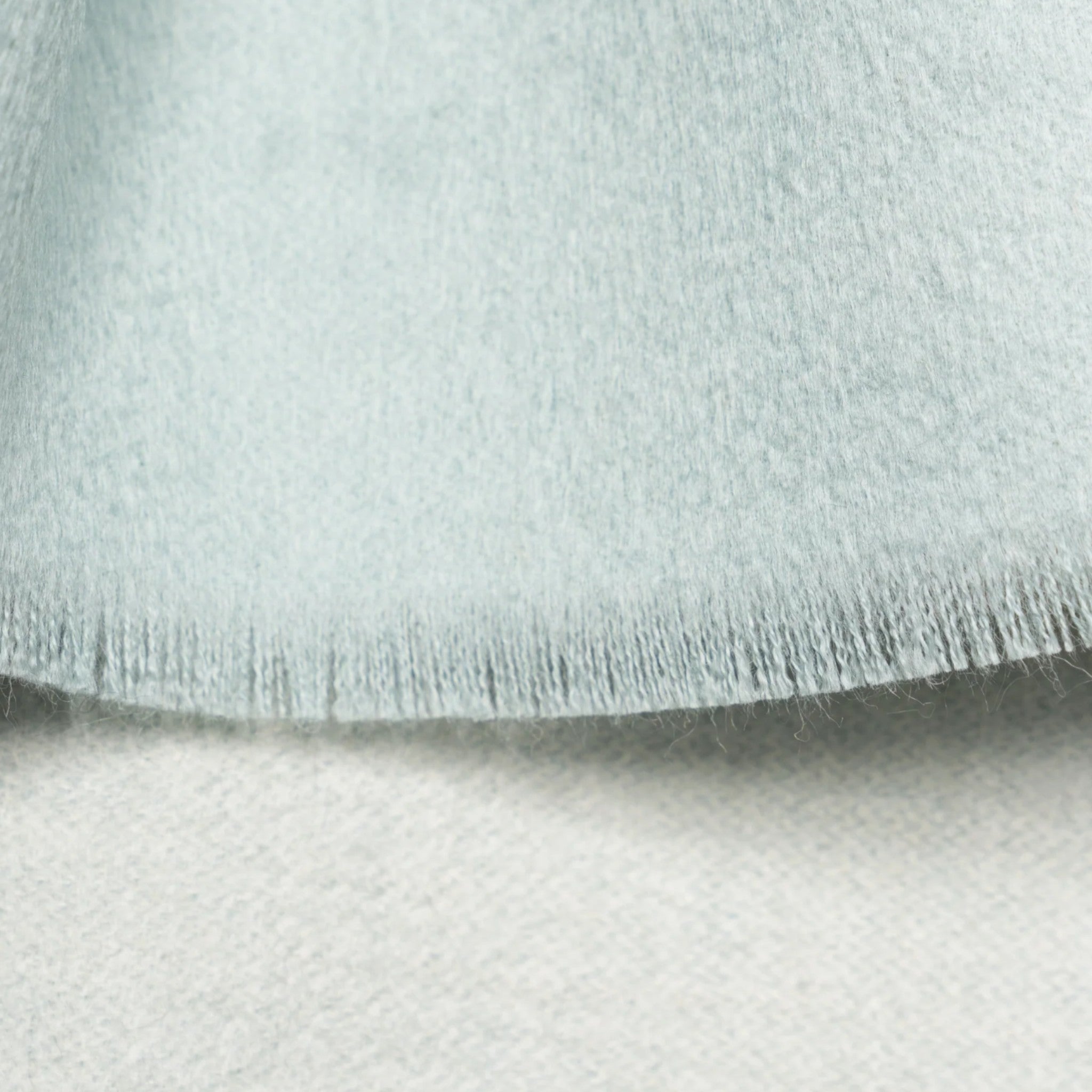 Close Up of Soft aquamarine reversible Suri alpaca scarf styled to show its contrasting two-colour finish