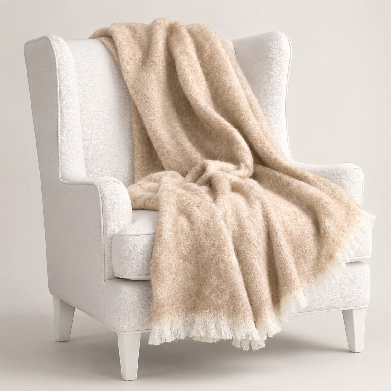 Brushed alpaca throw in Sand styled on chair, made from Australian alpaca fibre.