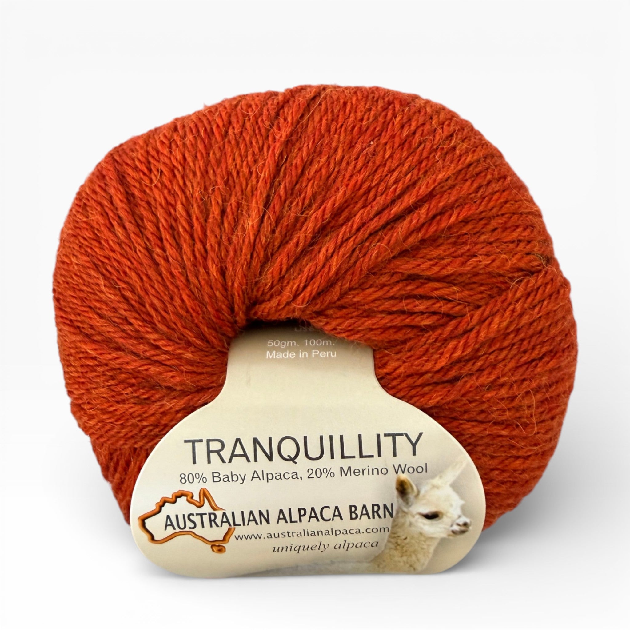 Ball of orange alpaca yarn with a label on a white background
