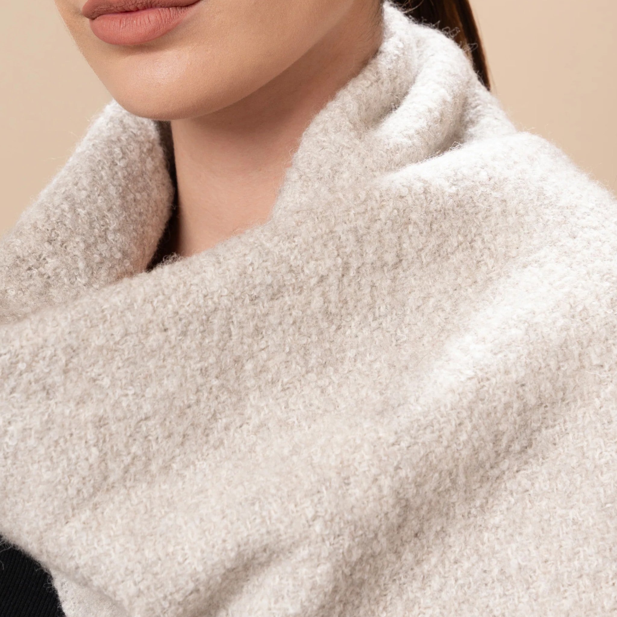 Close up of Soft light grey undyed bouclé scarf with textured finish and twisted fringed ends