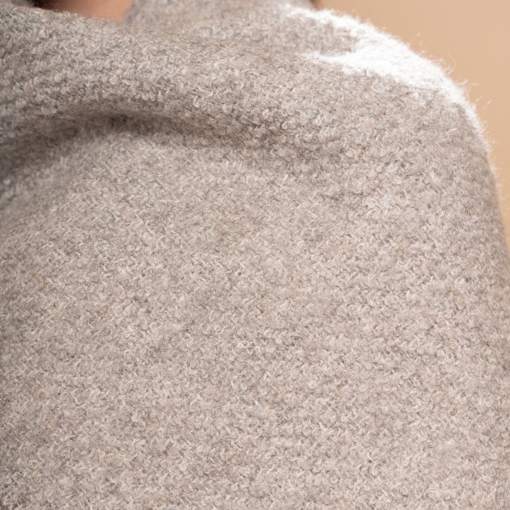 Close up of Natural mid grey alpaca and silk bouclé scarf styled with casual winter clothing