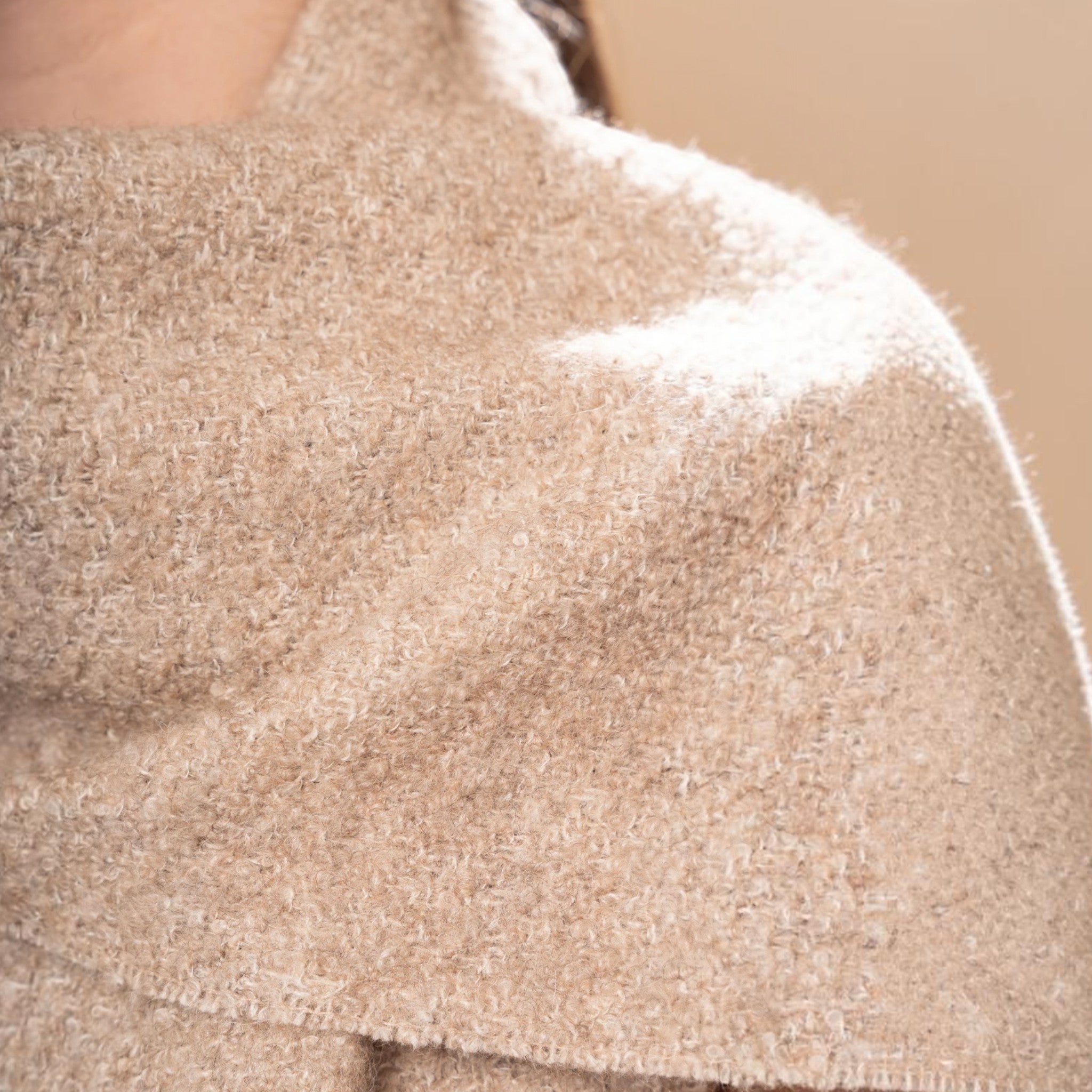 Close up of Soft oatmeal undyed bouclé scarf with textured finish and twisted fringed ends
