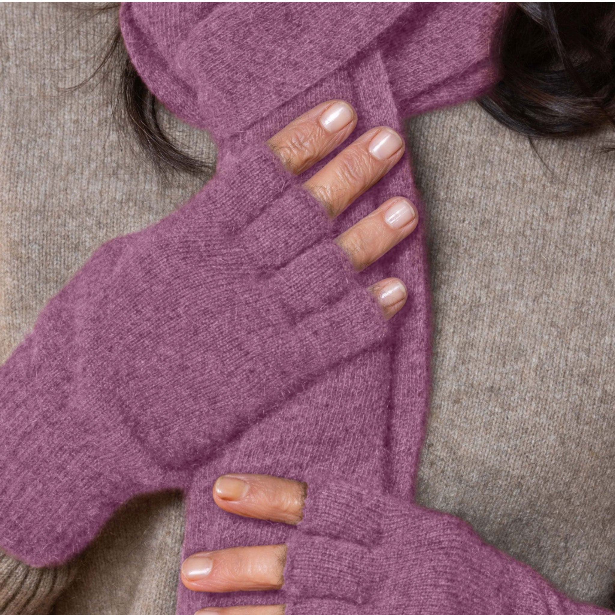 Purple fingerless possum gloves worn by a person on a neutral background