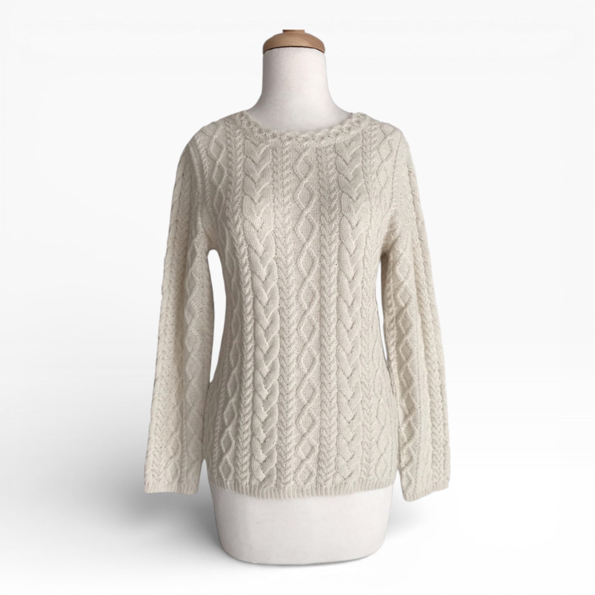 Cream cable knit sweater on a mannequin against a white background