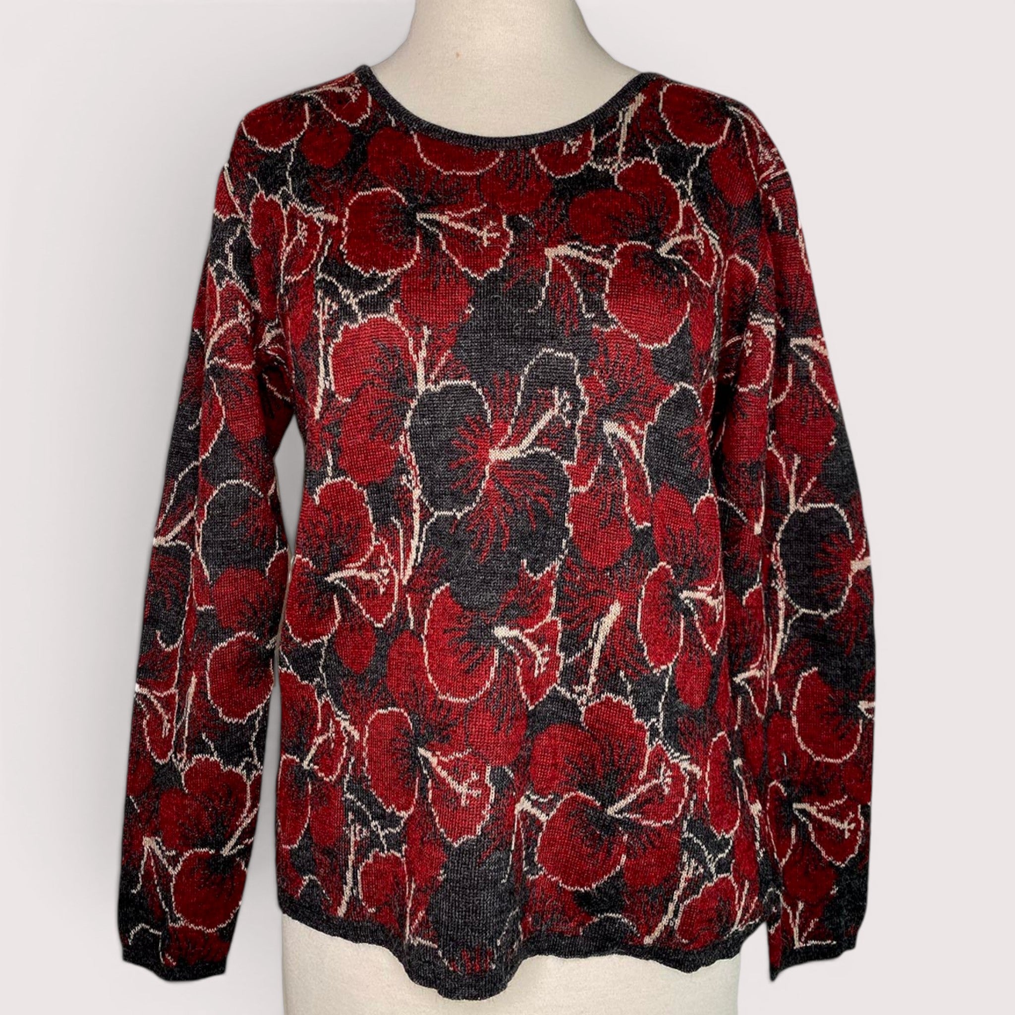 Woman wearing red hibiscus alpaca sweater with charcoal floral pattern