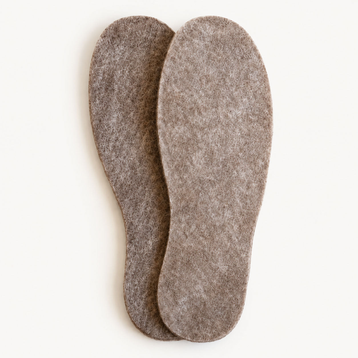 Pair of brown felted alpaca shoe inserts on a white background