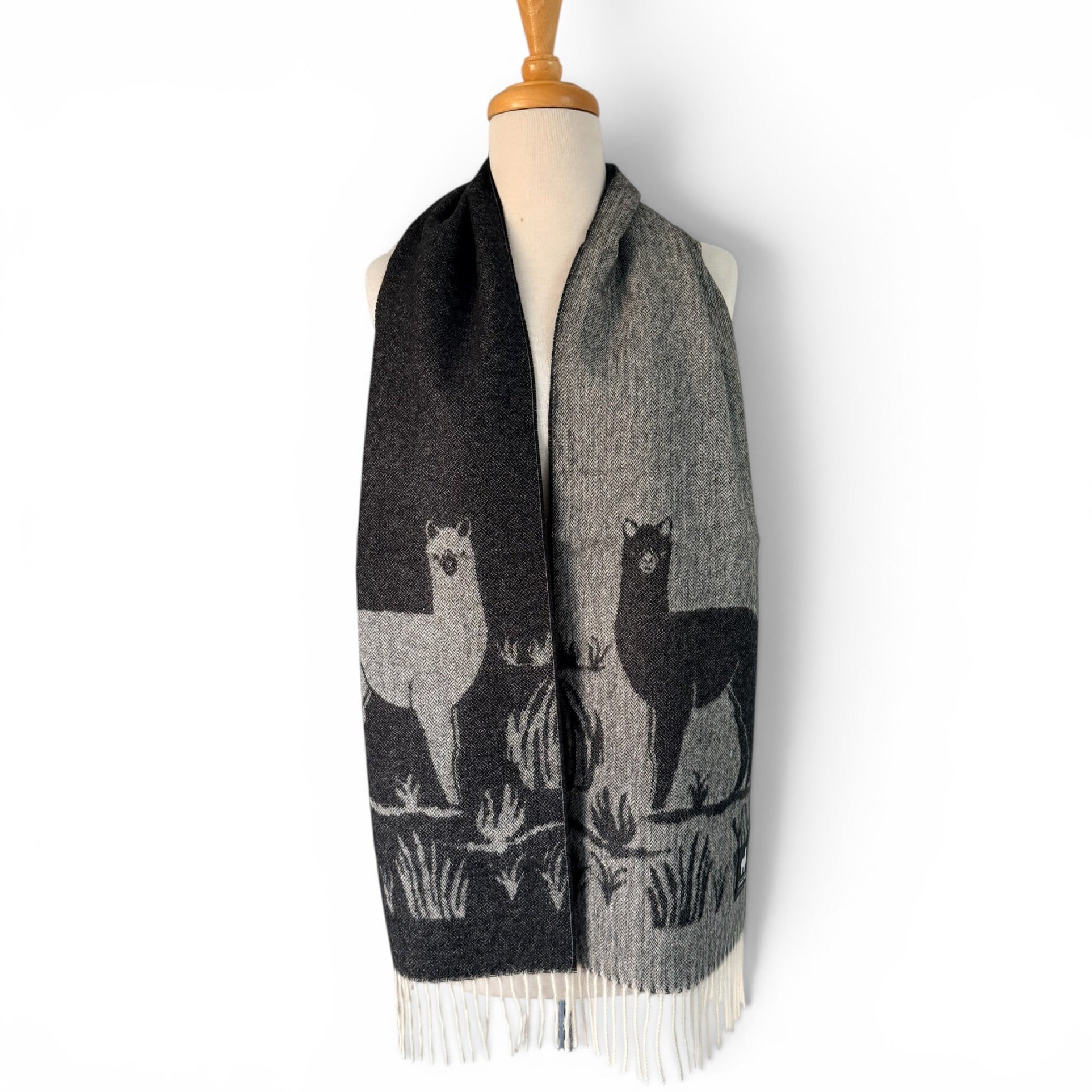 Monochrome jacquard scarf featuring repeating alpaca motifs in black and white
