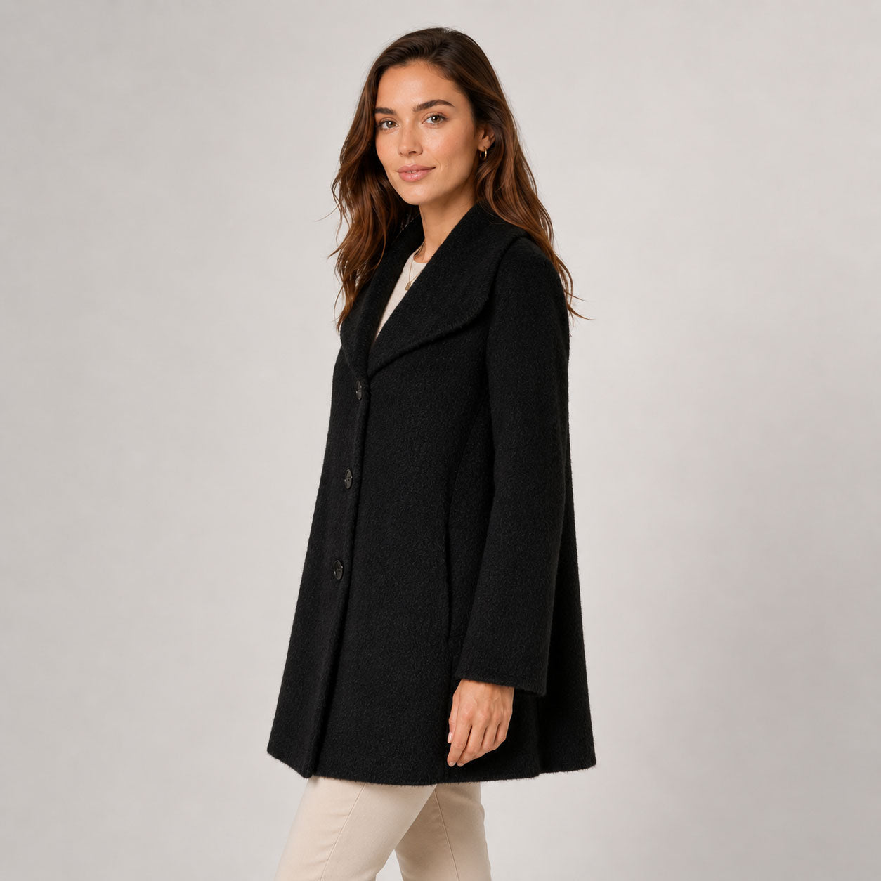 Side view of the black Alpaca Jade coat with a softly flared silhouette and three-button closure