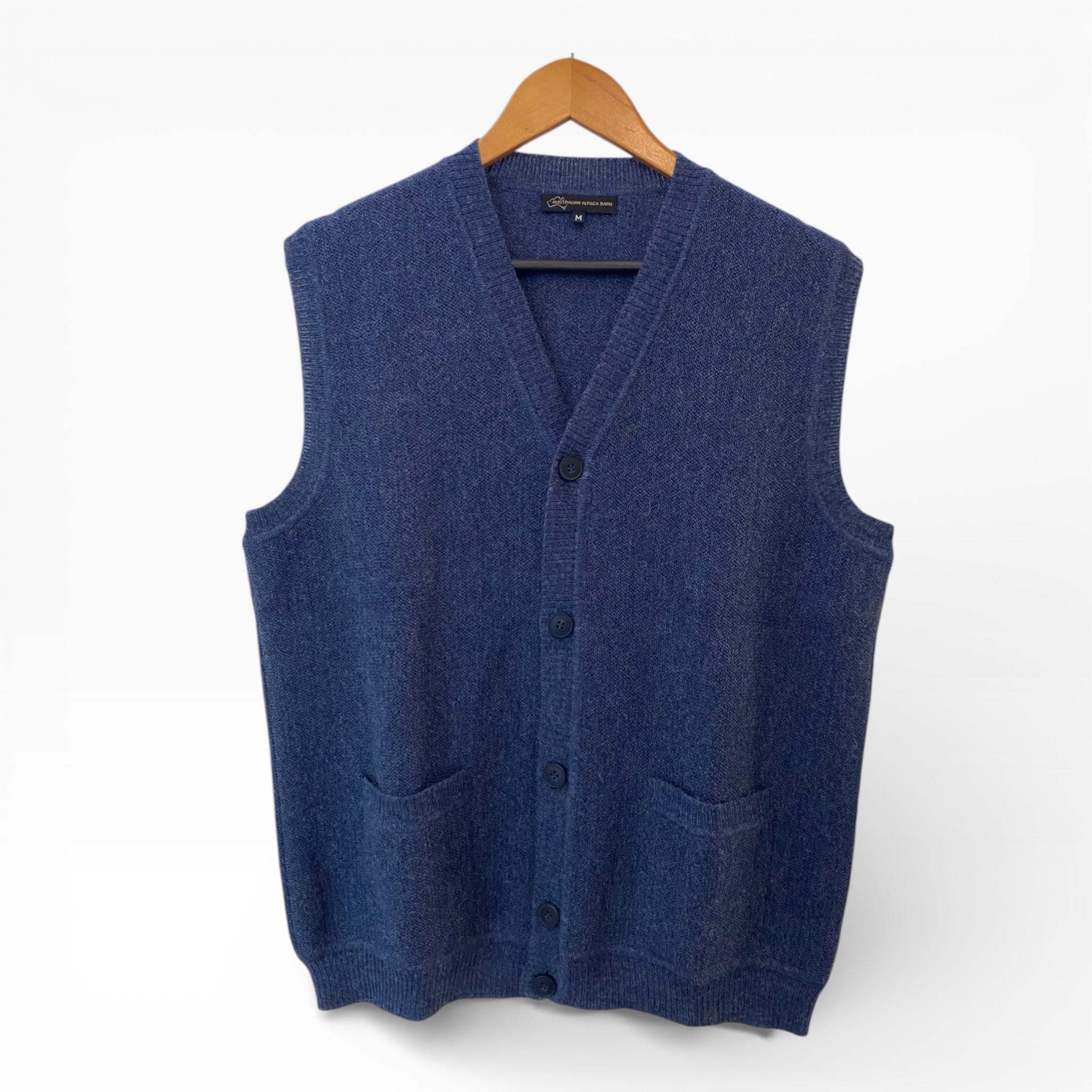 Blue sweater vest on a hanger against a white background