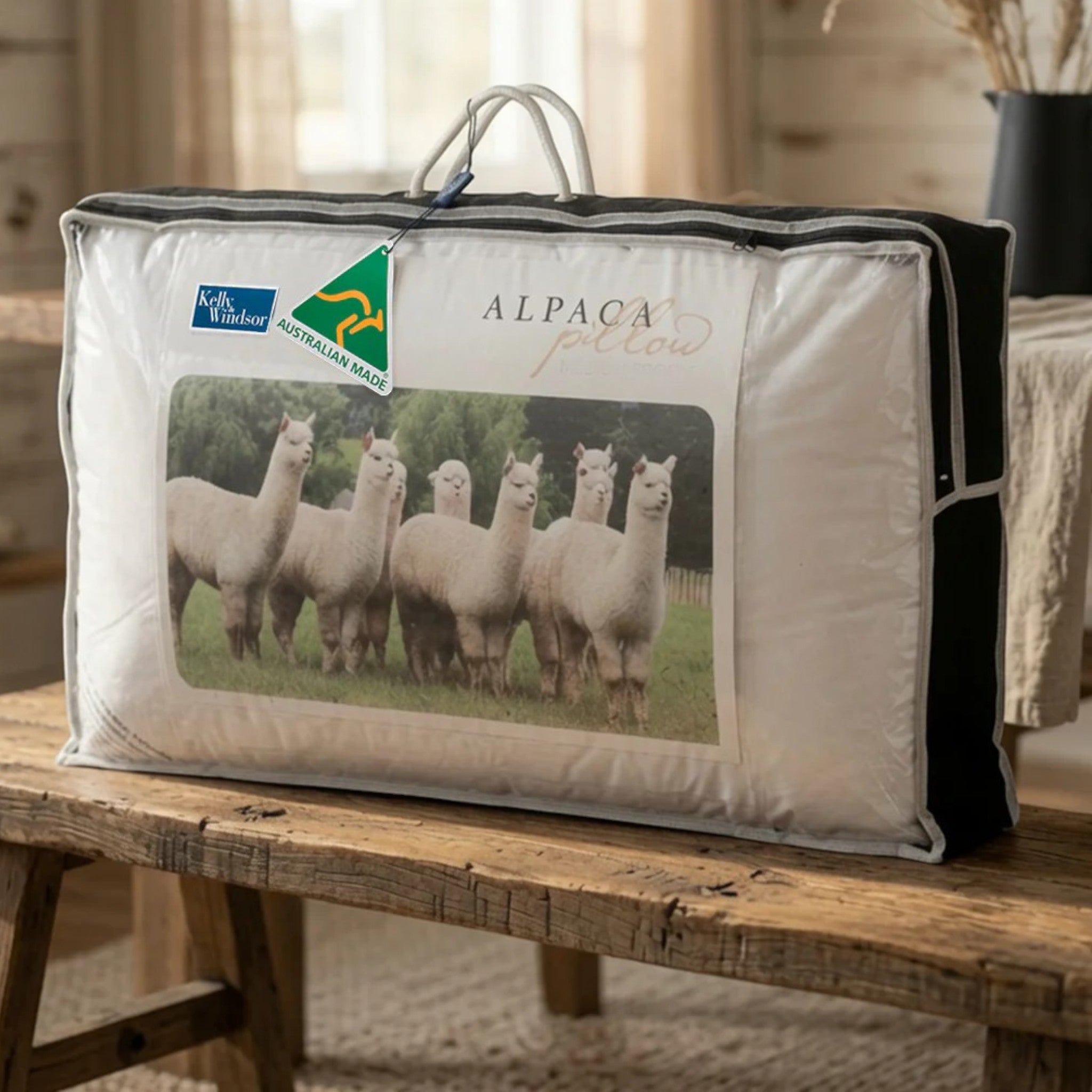 Alpaca pillow with Kelly Windsor branding on a wooden table