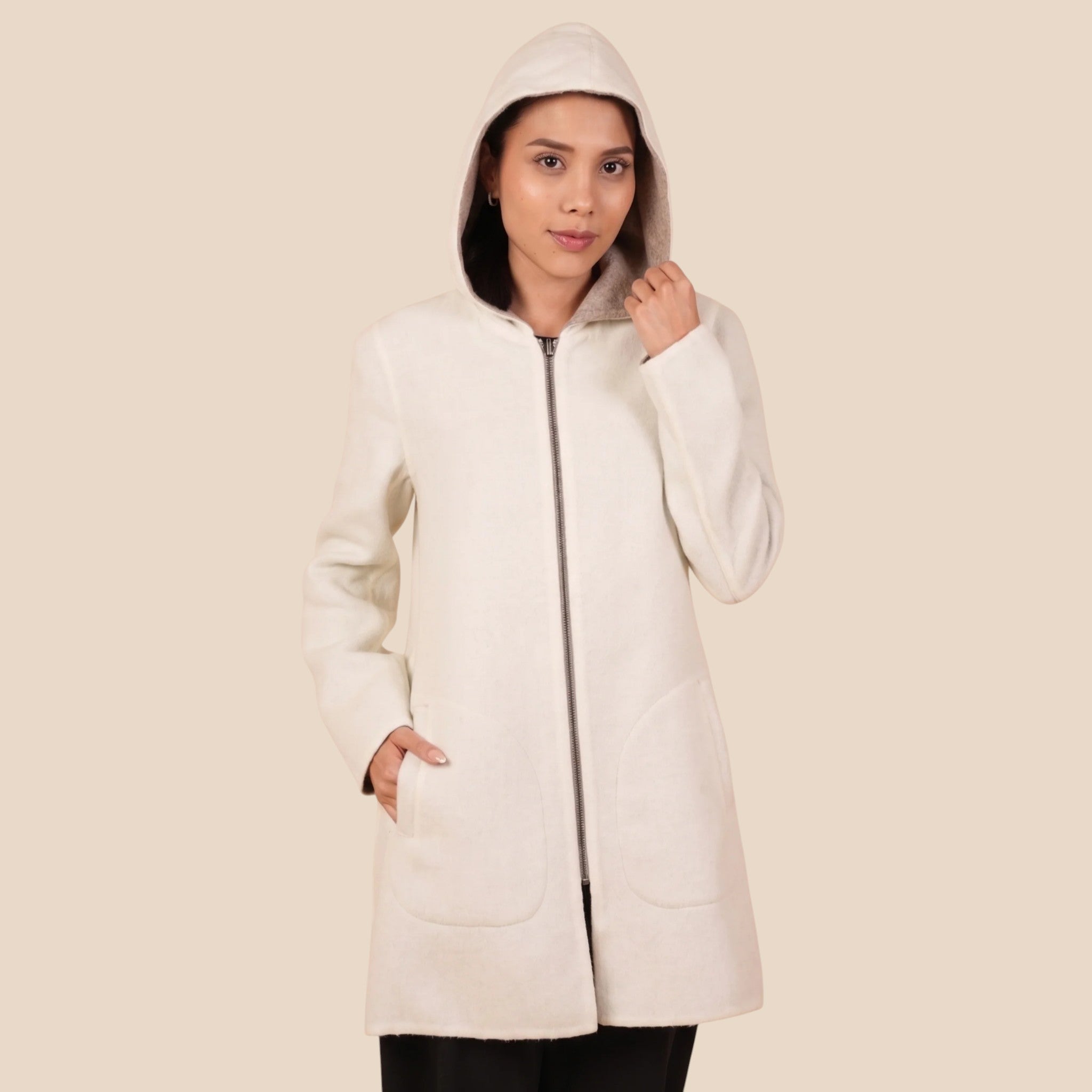 Woman wearing reversible alpaca coat, styled as a soft winter layering piece.