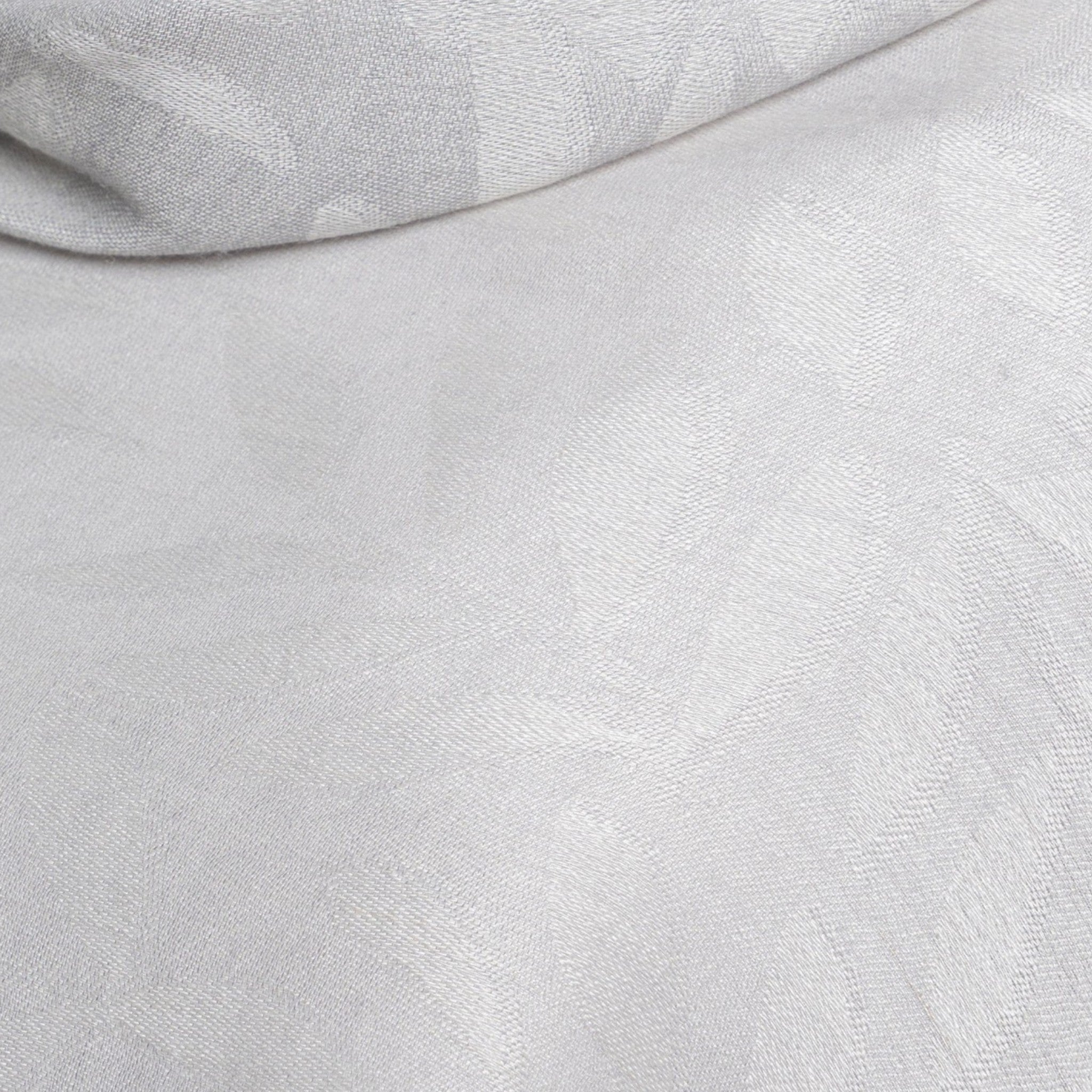 Close-up of light grey Baby Alpaca and Silk scarf showing the delicate two-tone leaf jacquard weave