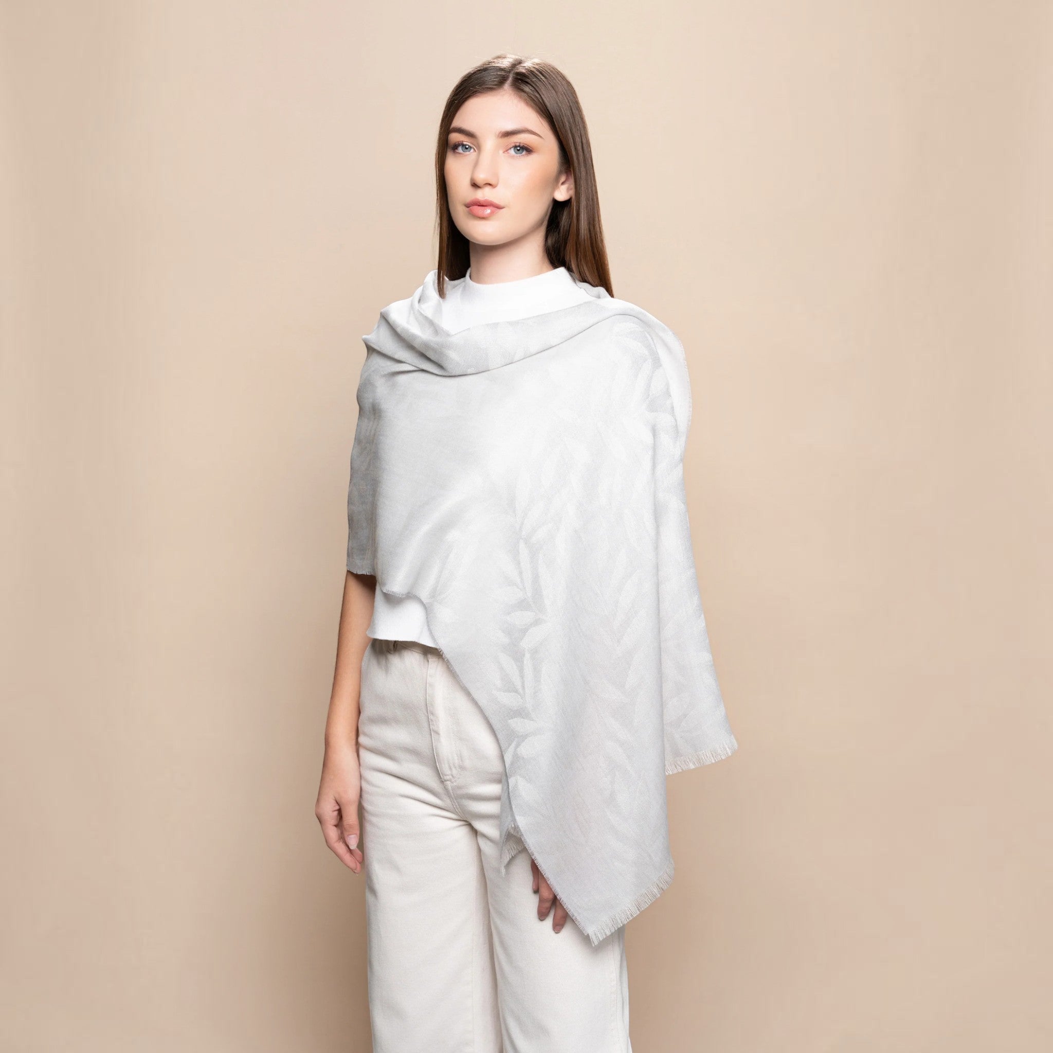 Light grey Leaf Jacquard scarf styled as a wrap, showcasing its soft drape, woven leaf design and frayed edging