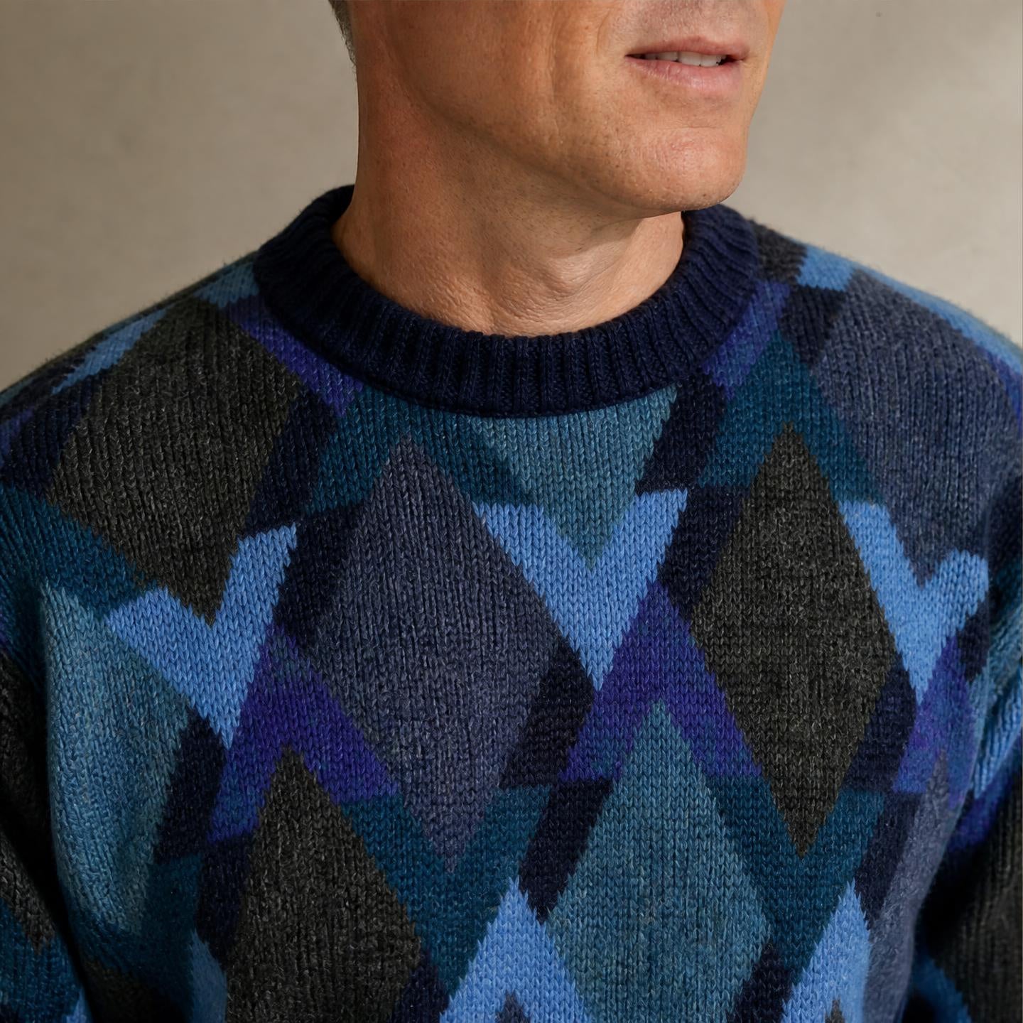 close up of Model wearing Men’s alpaca crew neck sweater in blue multicolour pattern